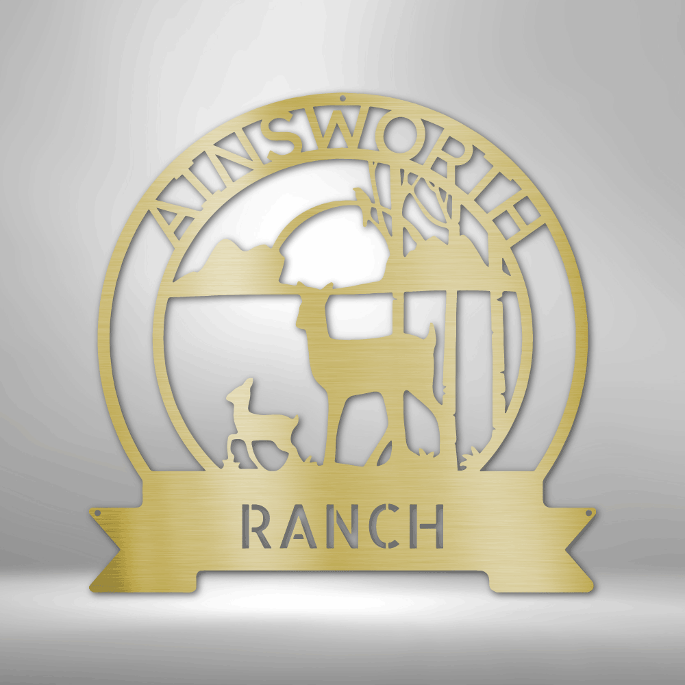 Circular gold-colored metal sign or emblem for ’Ainsworth Ranch’ featuring silhouettes of deer and trees.