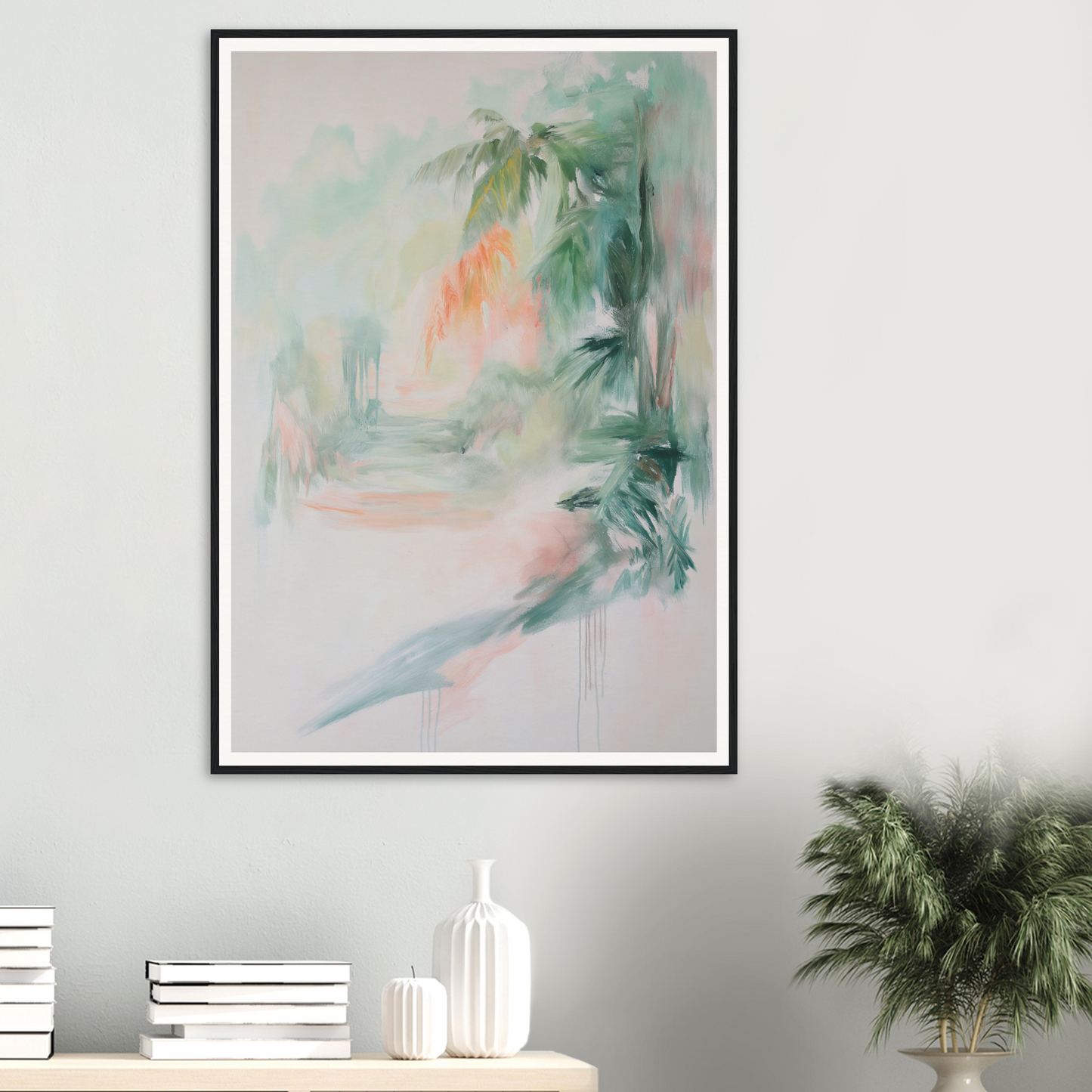 Framed wall art of a tropical scene above a light-colored shelf with elegant room decor.
