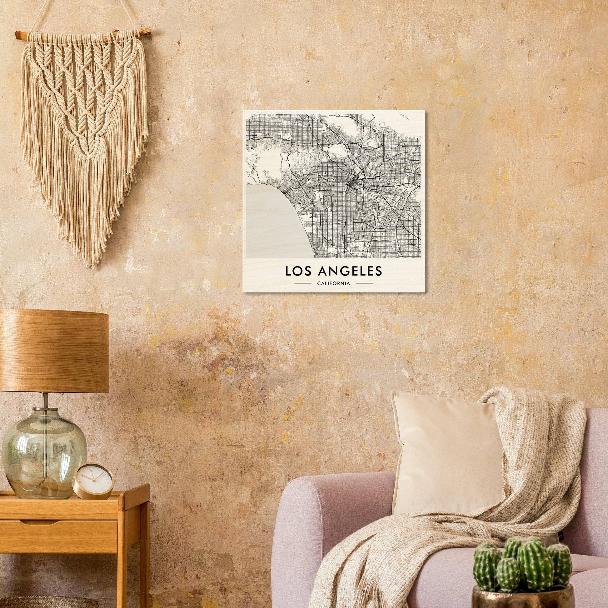 Macramé wall hanging with fringe above a Los Angeles city map canvas print.
