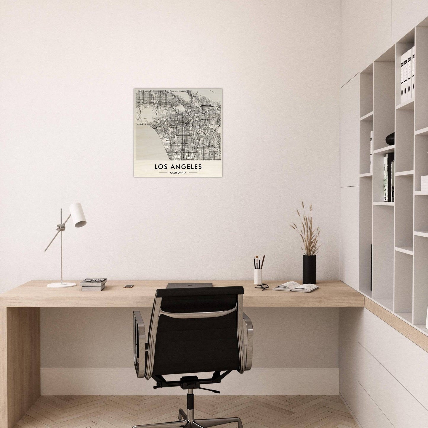Minimalist home office workspace with a wooden desk, black office chair, and wall-mounted map of Los Angeles.
