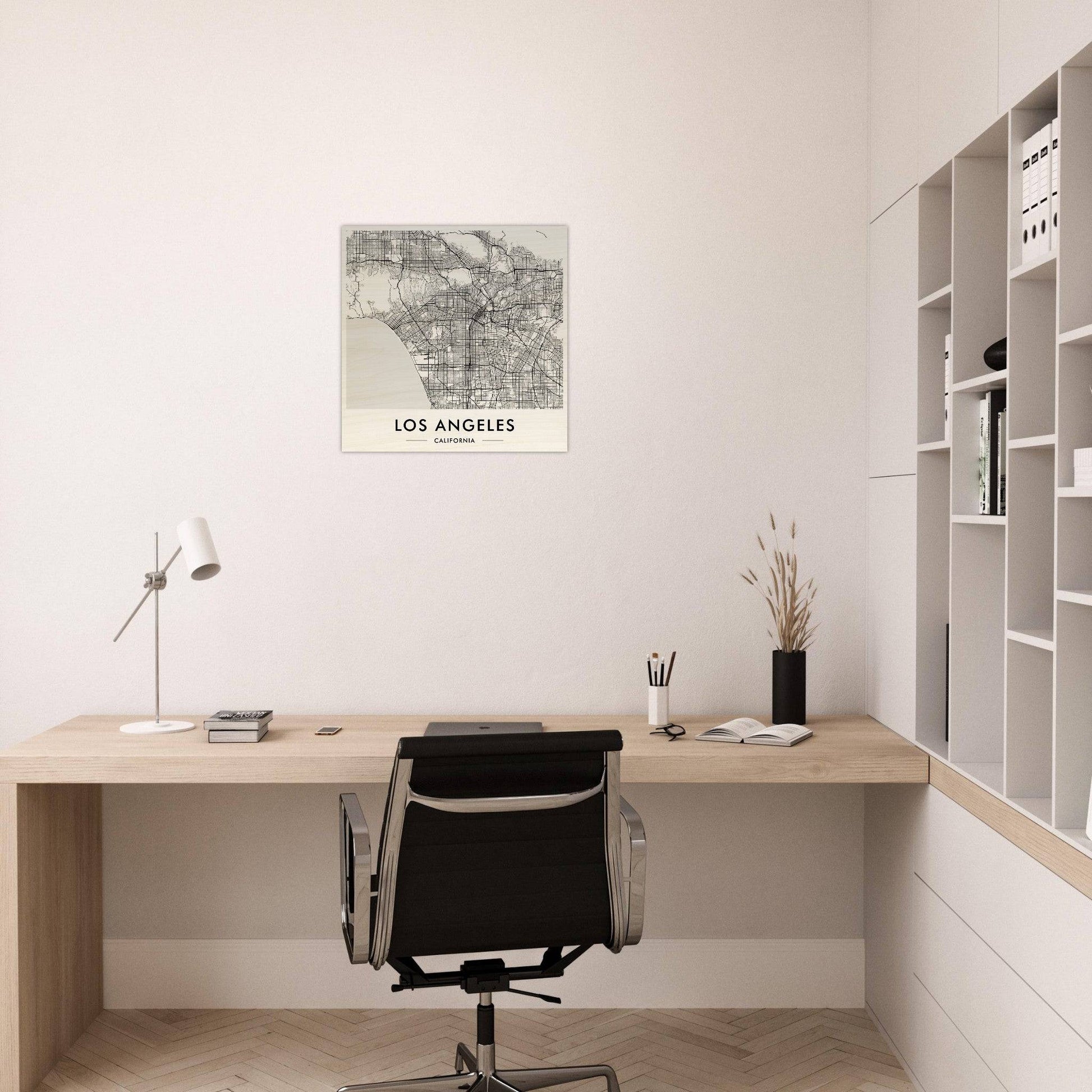 Minimalist home office workspace with a wooden desk, black office chair, and wall-mounted map of Los Angeles.