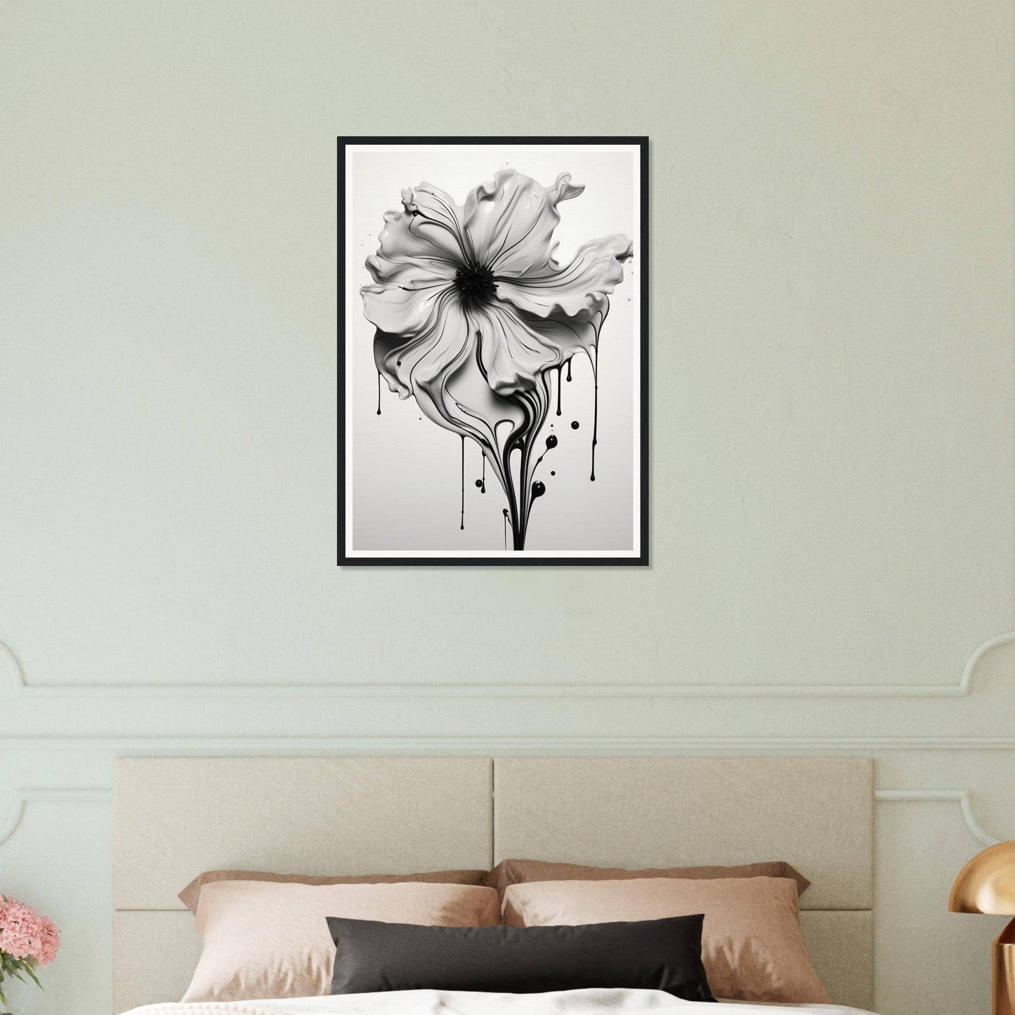 A black and white flower on a wall above a bed