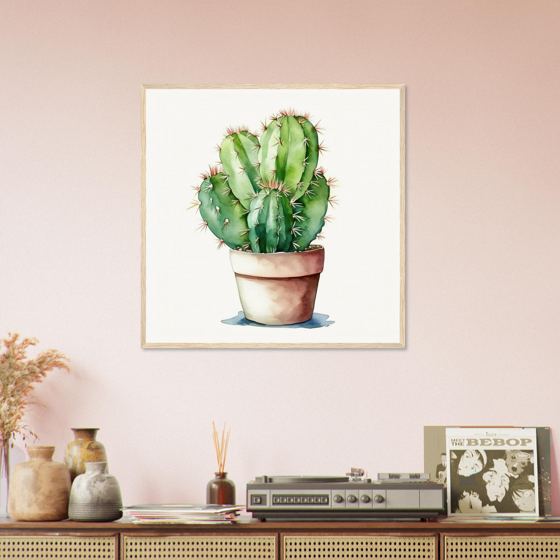 A cactus plant in a pot on a pink wall