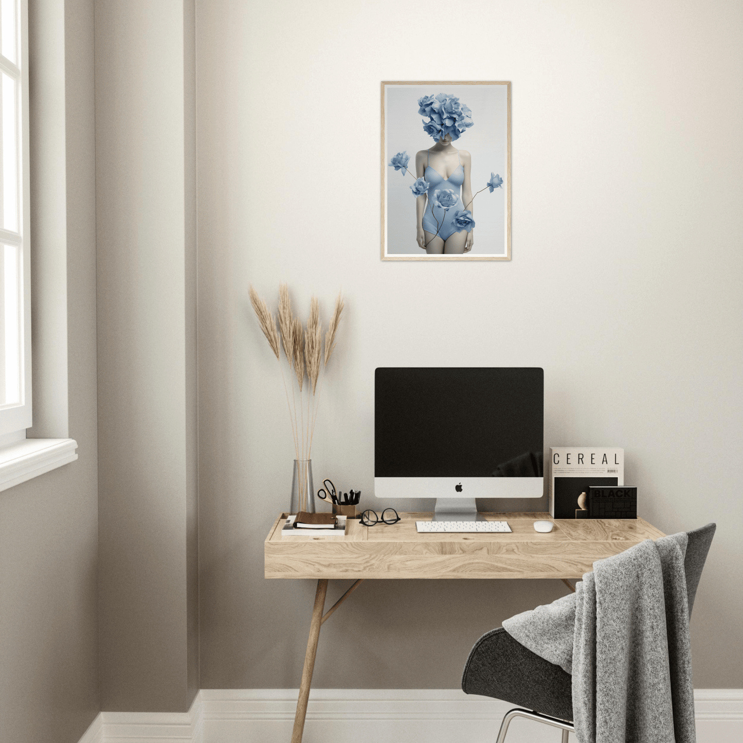Minimalist wooden desk with a computer monitor and decorative artwork above.