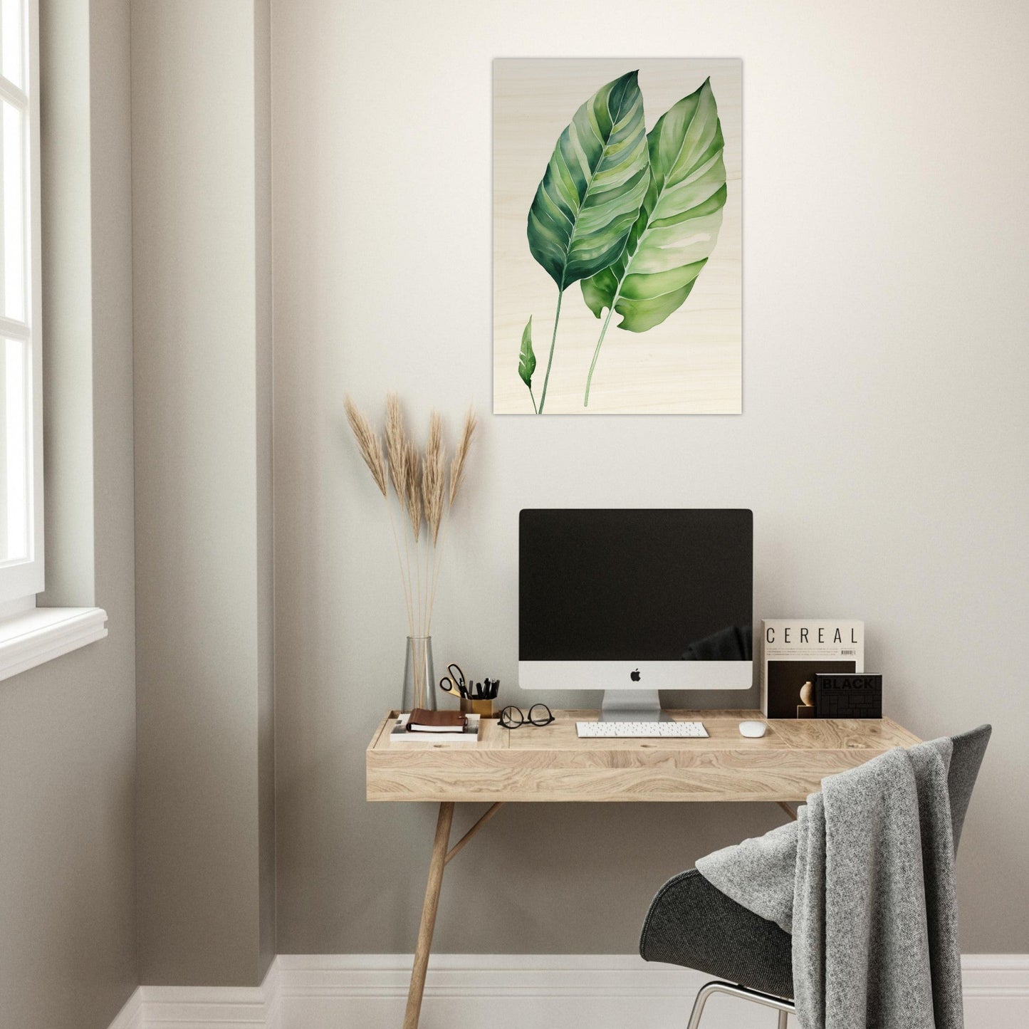 A computer desk with a green leaf on it