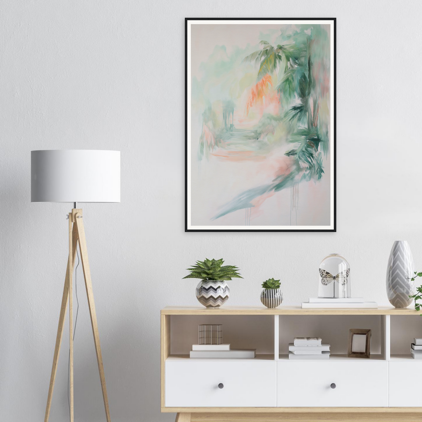 Minimalist living room with framed wall art above a wooden console and a tripod lamp.