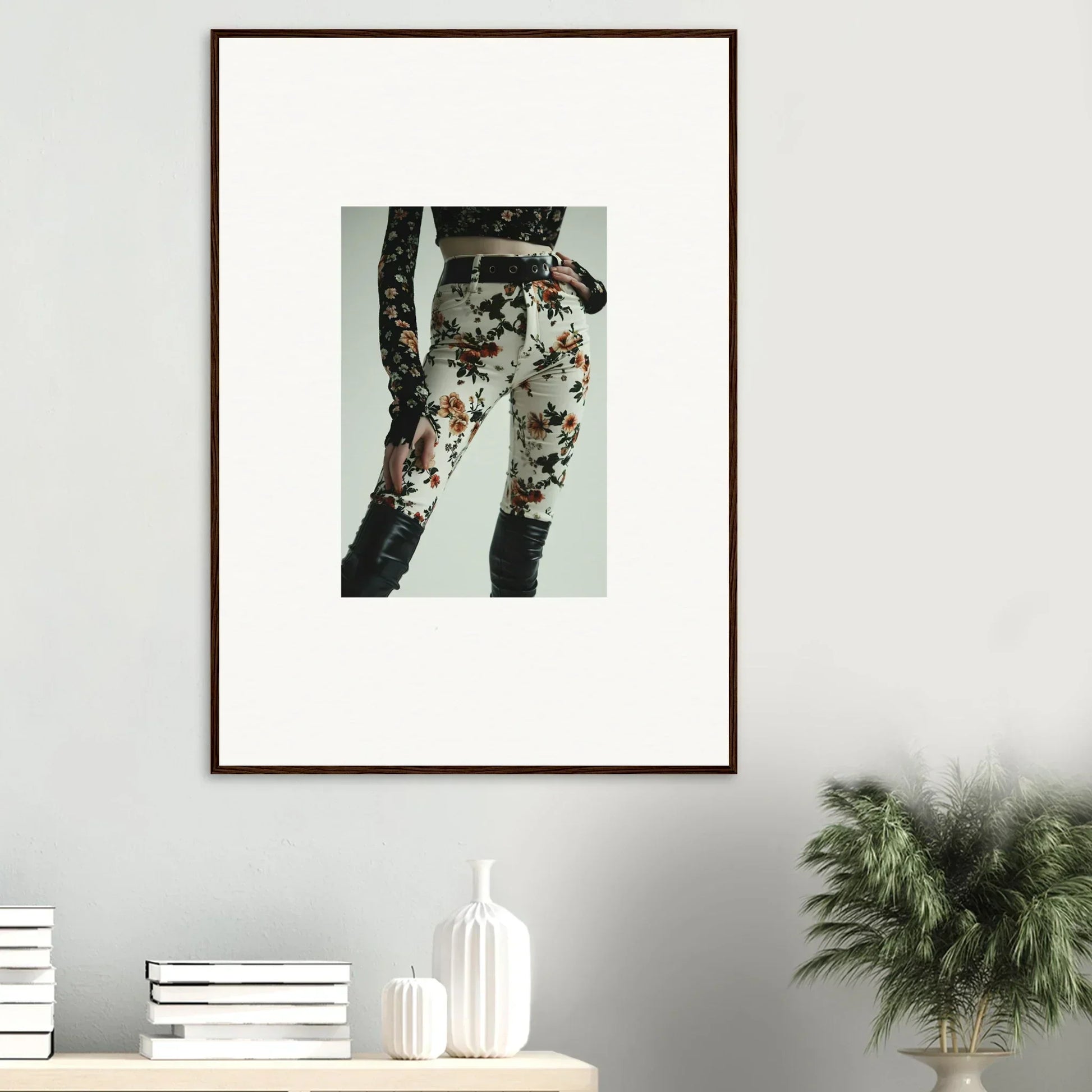 Framed artwork depicting floral-patterned pants or leggings on a person’s lower body.