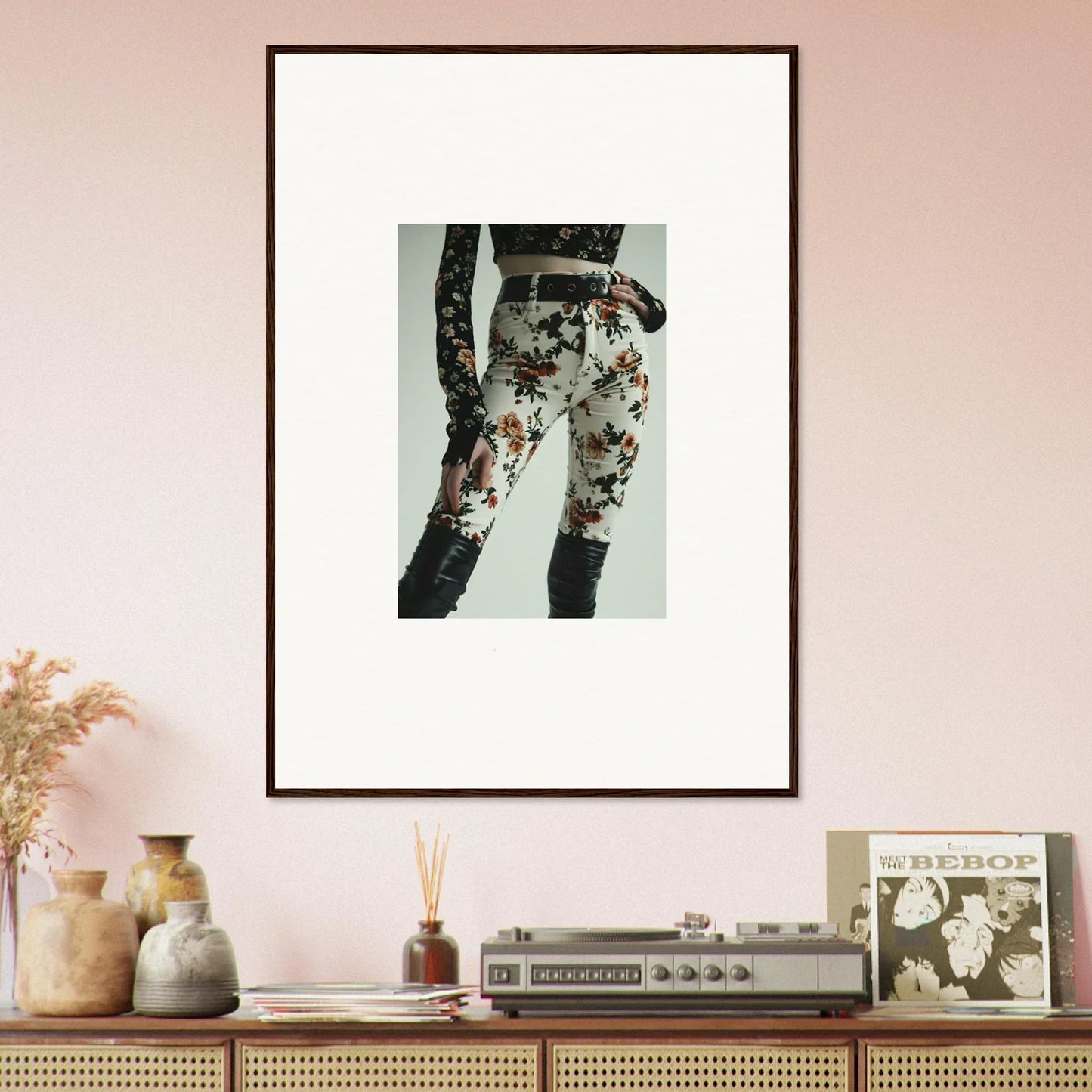 Framed artwork depicting floral-patterned pants on a person’s lower body.