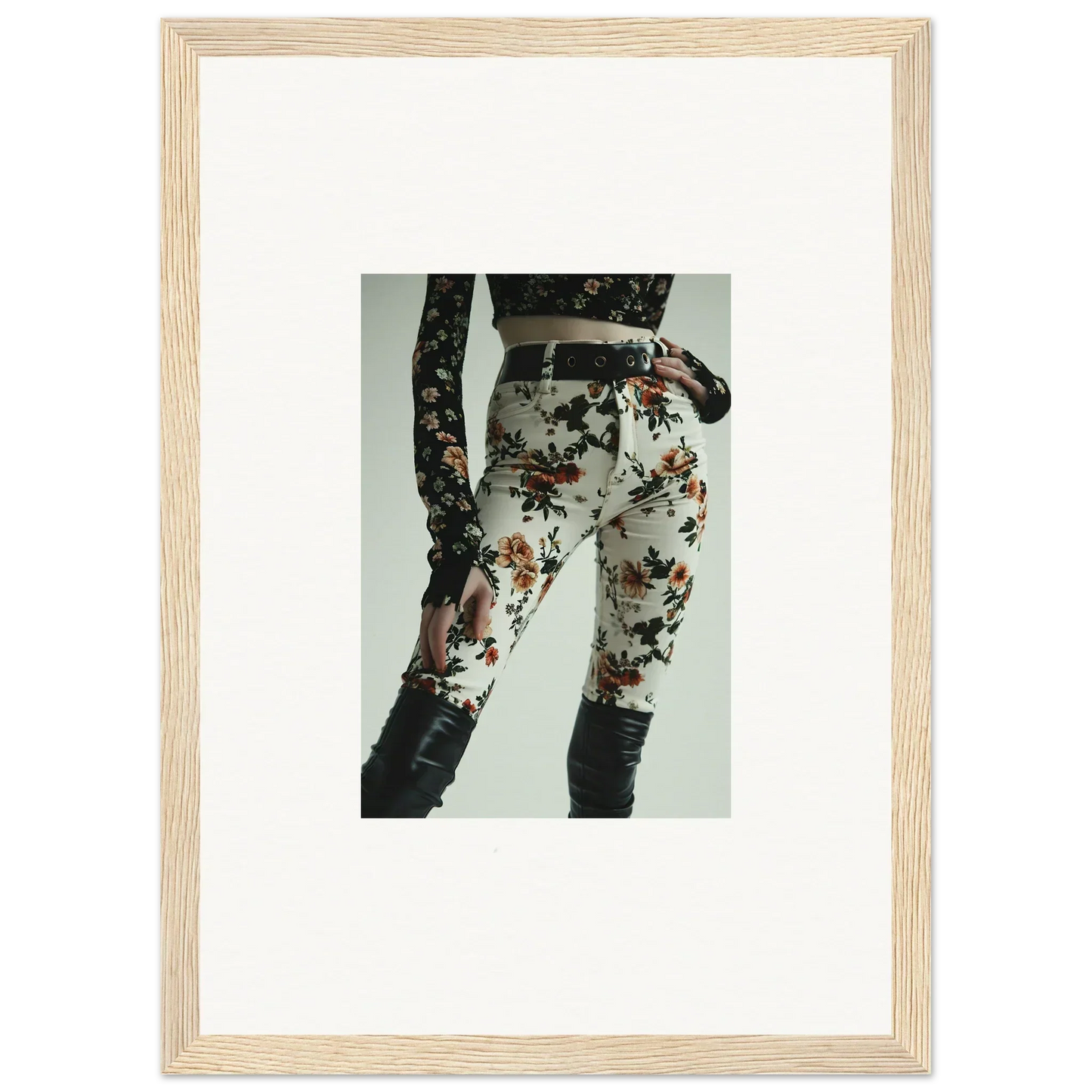 Framed photograph of a person wearing floral-patterned pants and a black top.