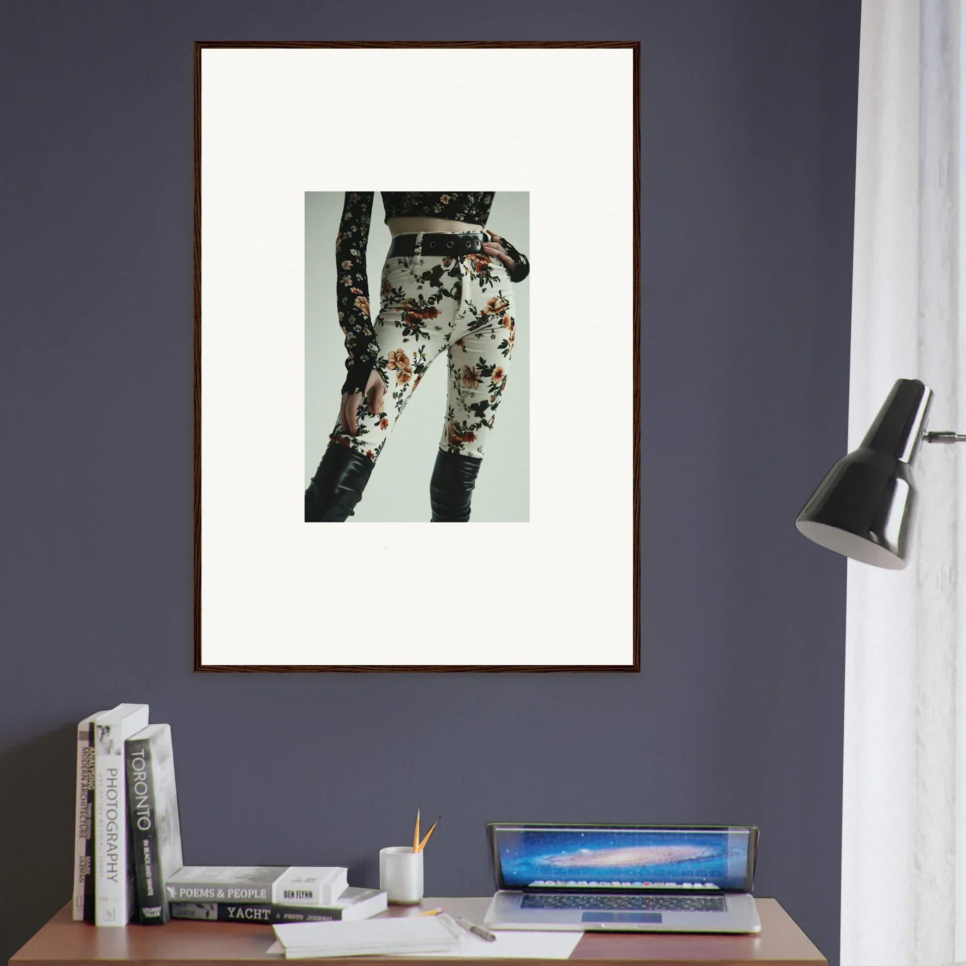 Framed artwork depicting floral-patterned pants on a person’s lower body.