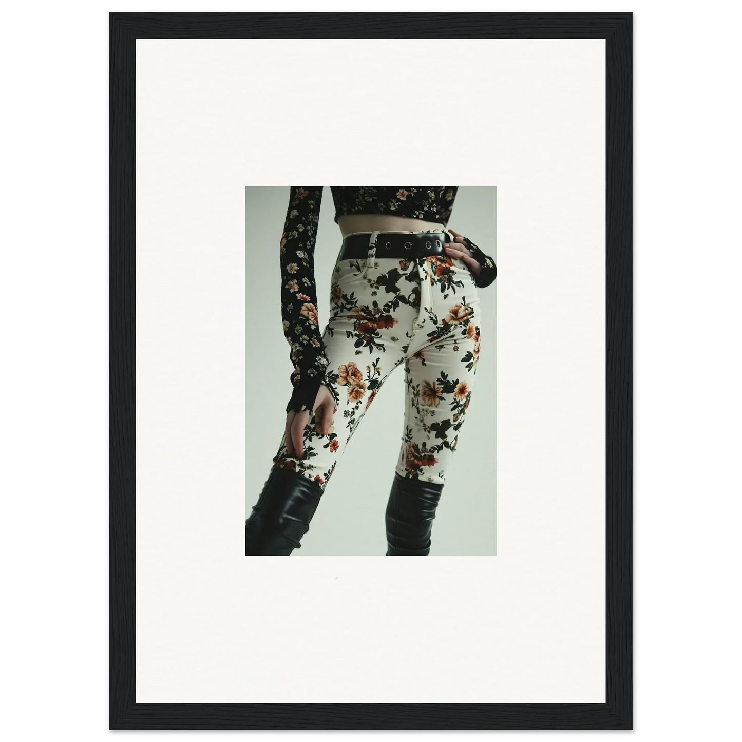 Floral-patterned white pants with a black belt and lace-up detail on the side.