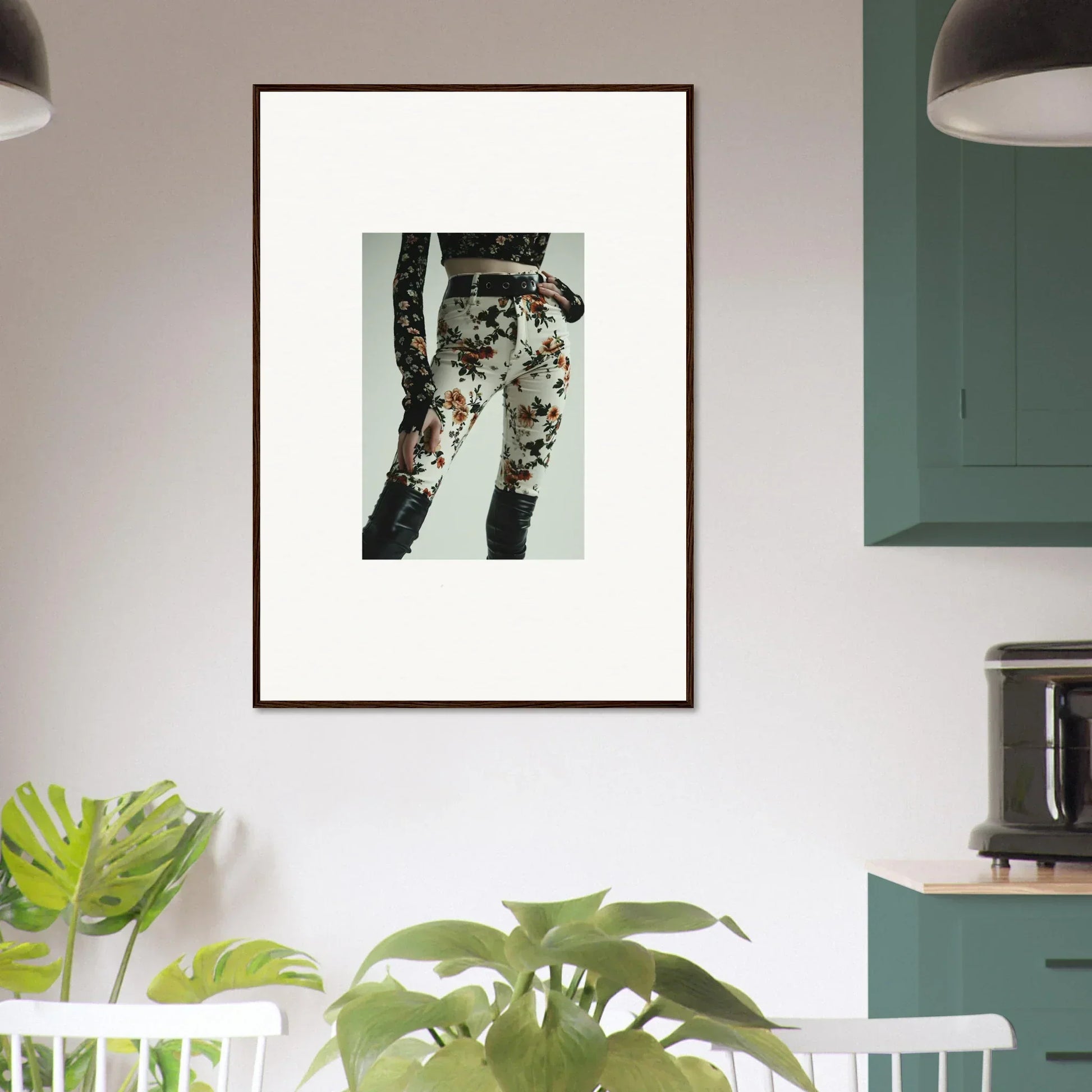 Framed artwork depicting a person’s legs wearing floral-patterned pants.