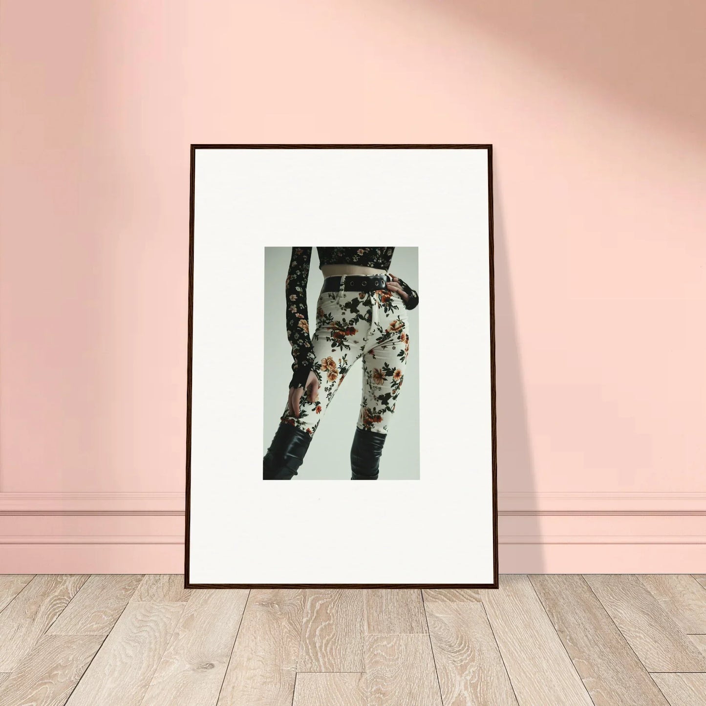 Framed artwork depicting a person’s legs wearing floral-patterned jeans.