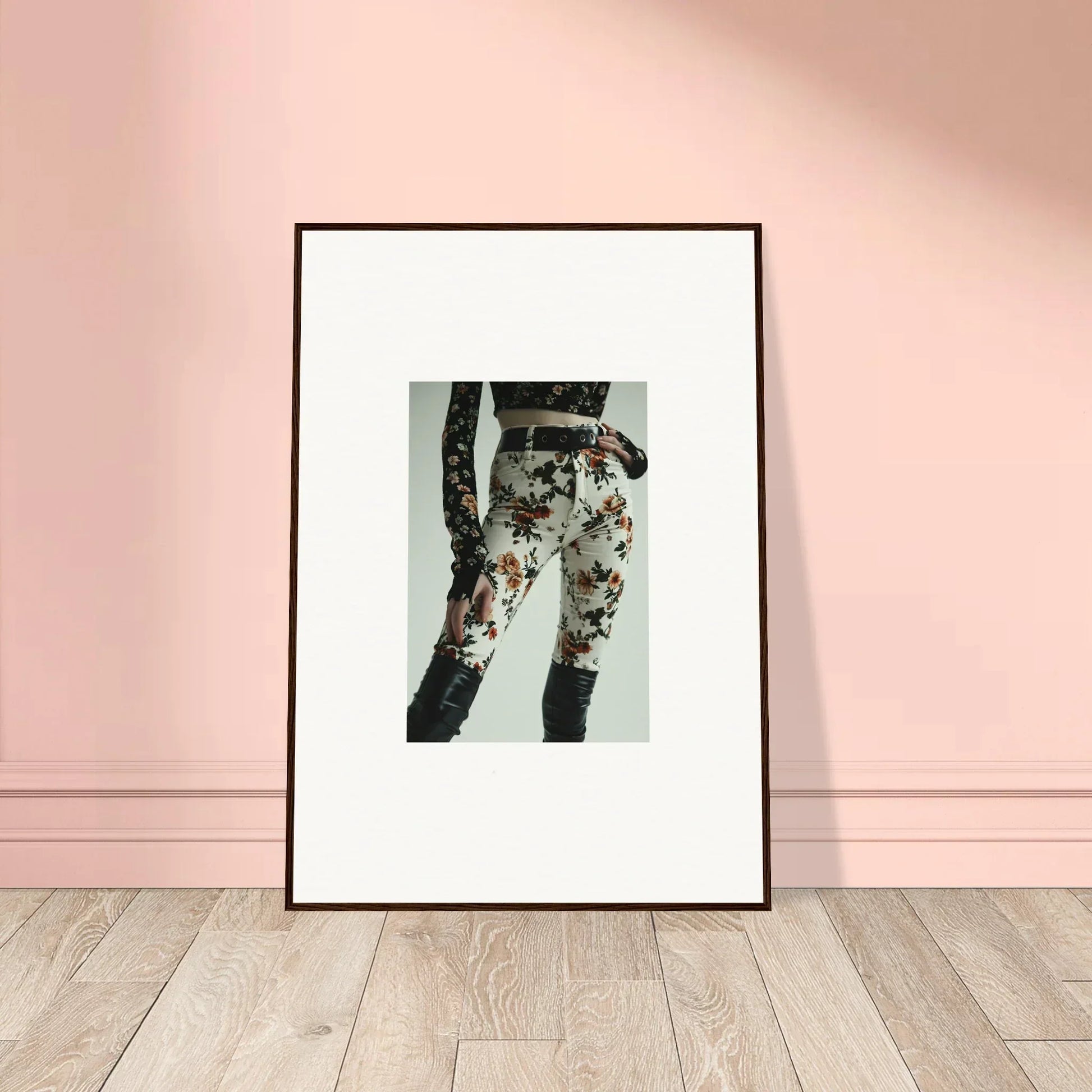 Framed artwork depicting a person’s legs wearing floral-patterned jeans.