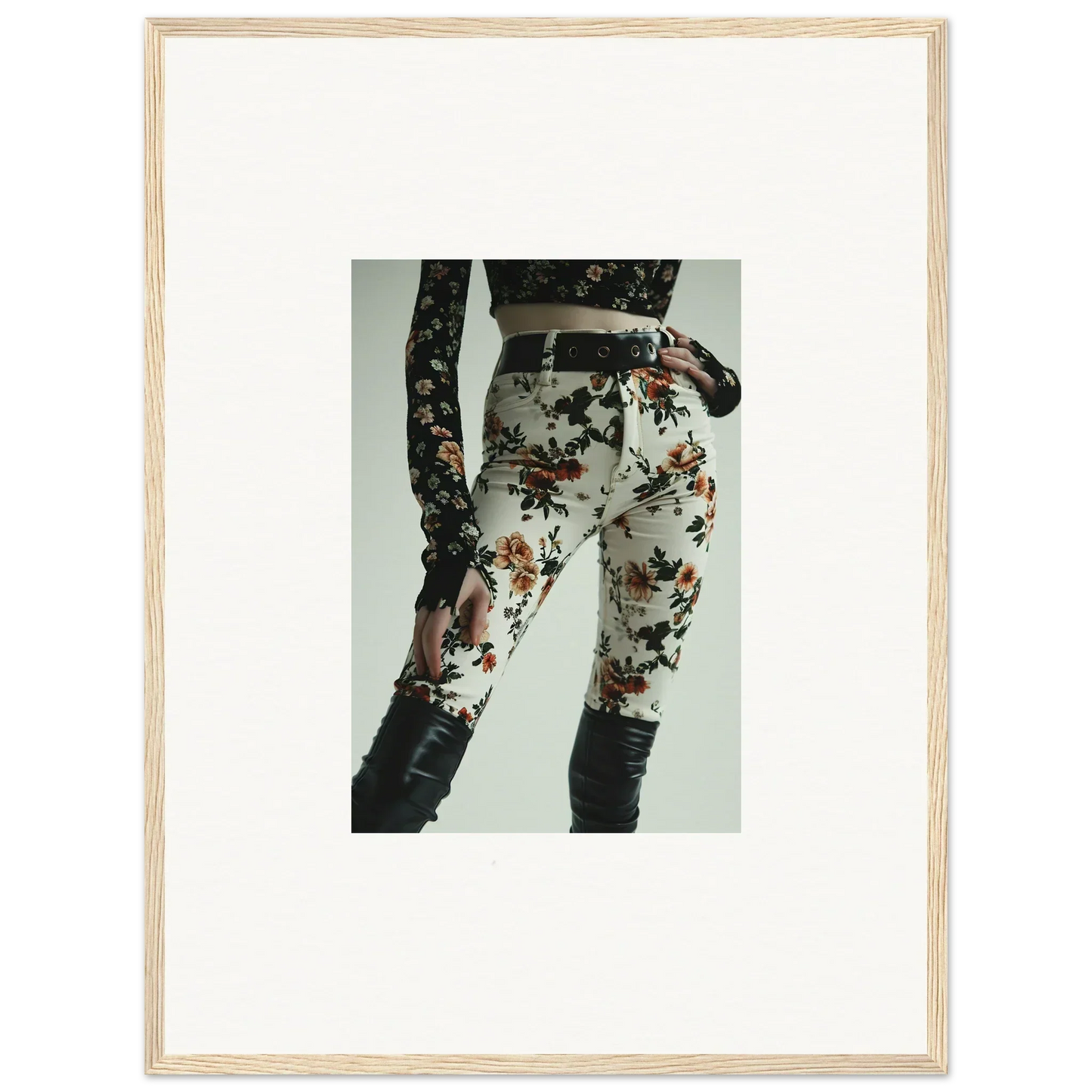 Framed photograph of a person wearing floral-patterned pants and a lace top.