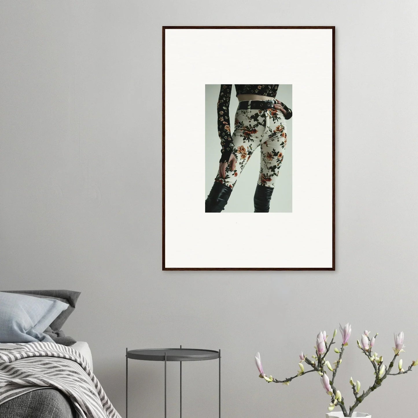 Framed artwork depicting floral-patterned pants or leggings on a person’s legs.