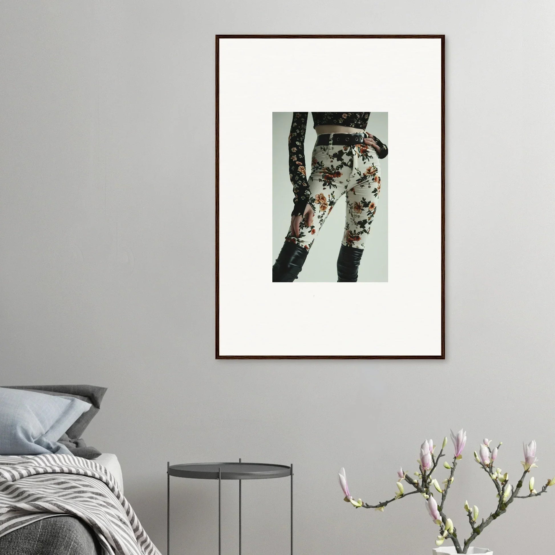 Framed artwork depicting floral-patterned pants or leggings on a person’s legs.
