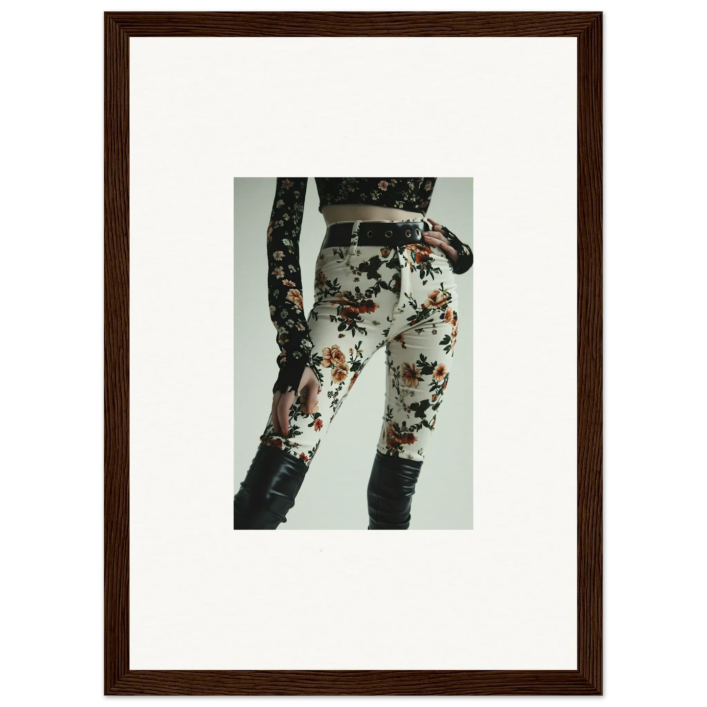 Floral print pants or leggings with a black belt and lace-up detail on the side.