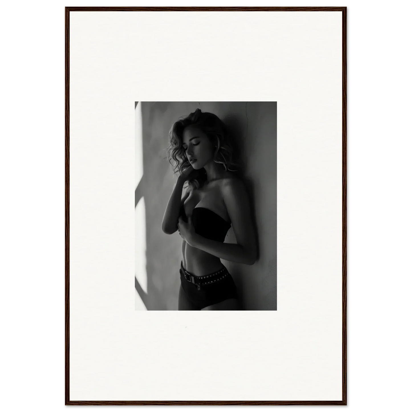 Black and white photograph of a woman in a strapless top, framed and matted.