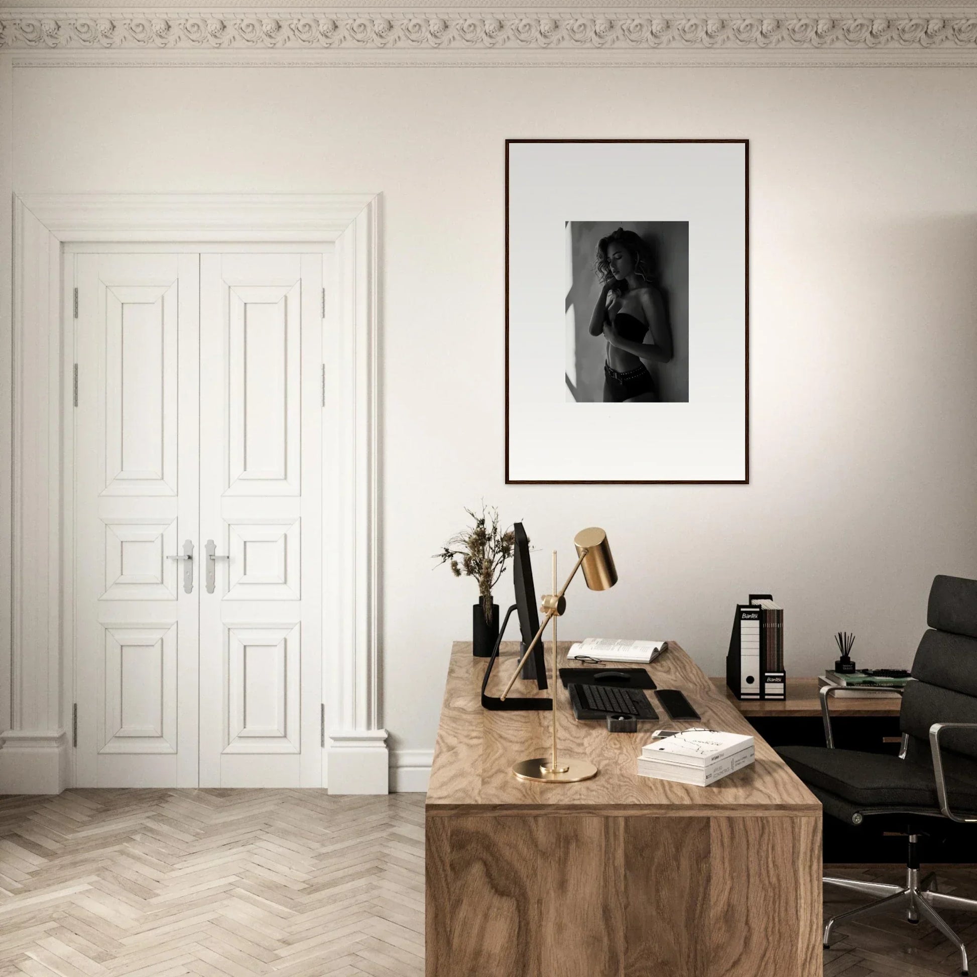 Wooden desk with various office items and a framed photograph on the wall above.