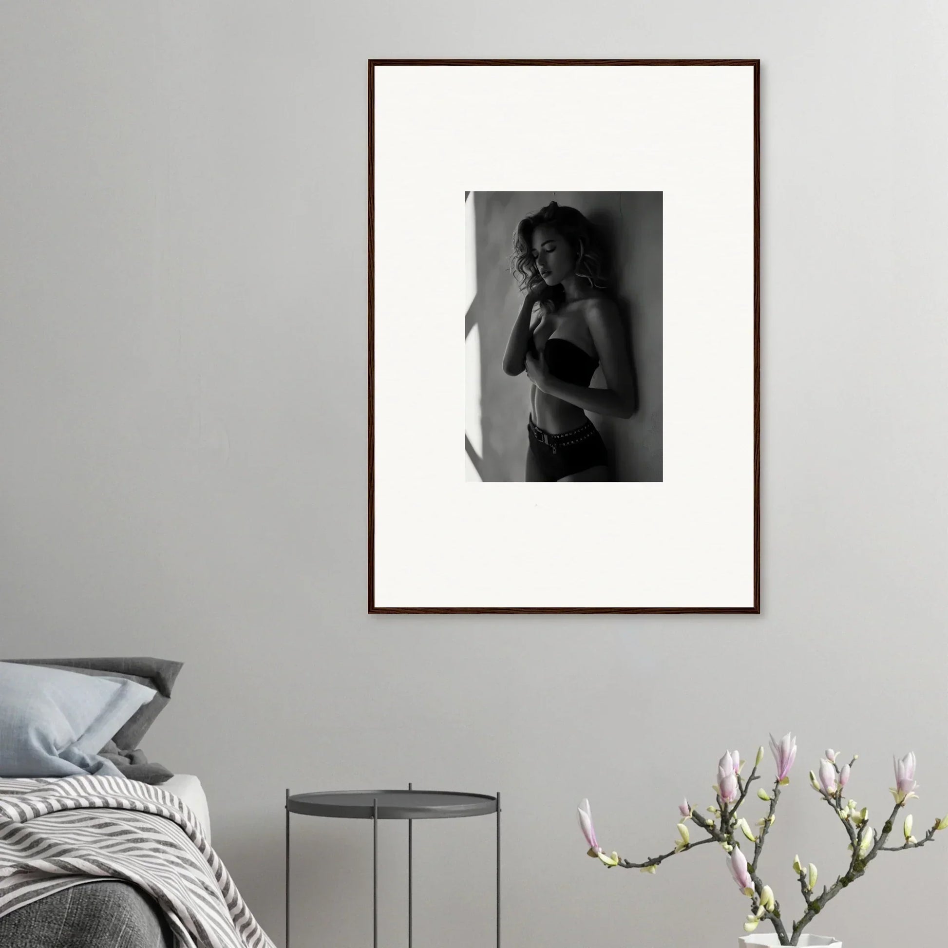 Framed black and white photograph of a woman in lingerie posing against a wall.