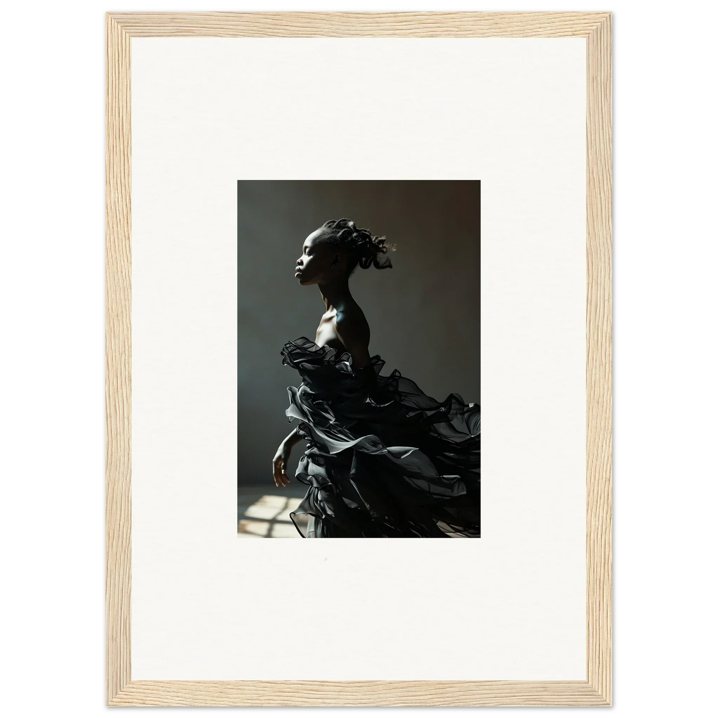 Framed black-and-white photograph of a sculptural figure with flowing, dramatic drapery.
