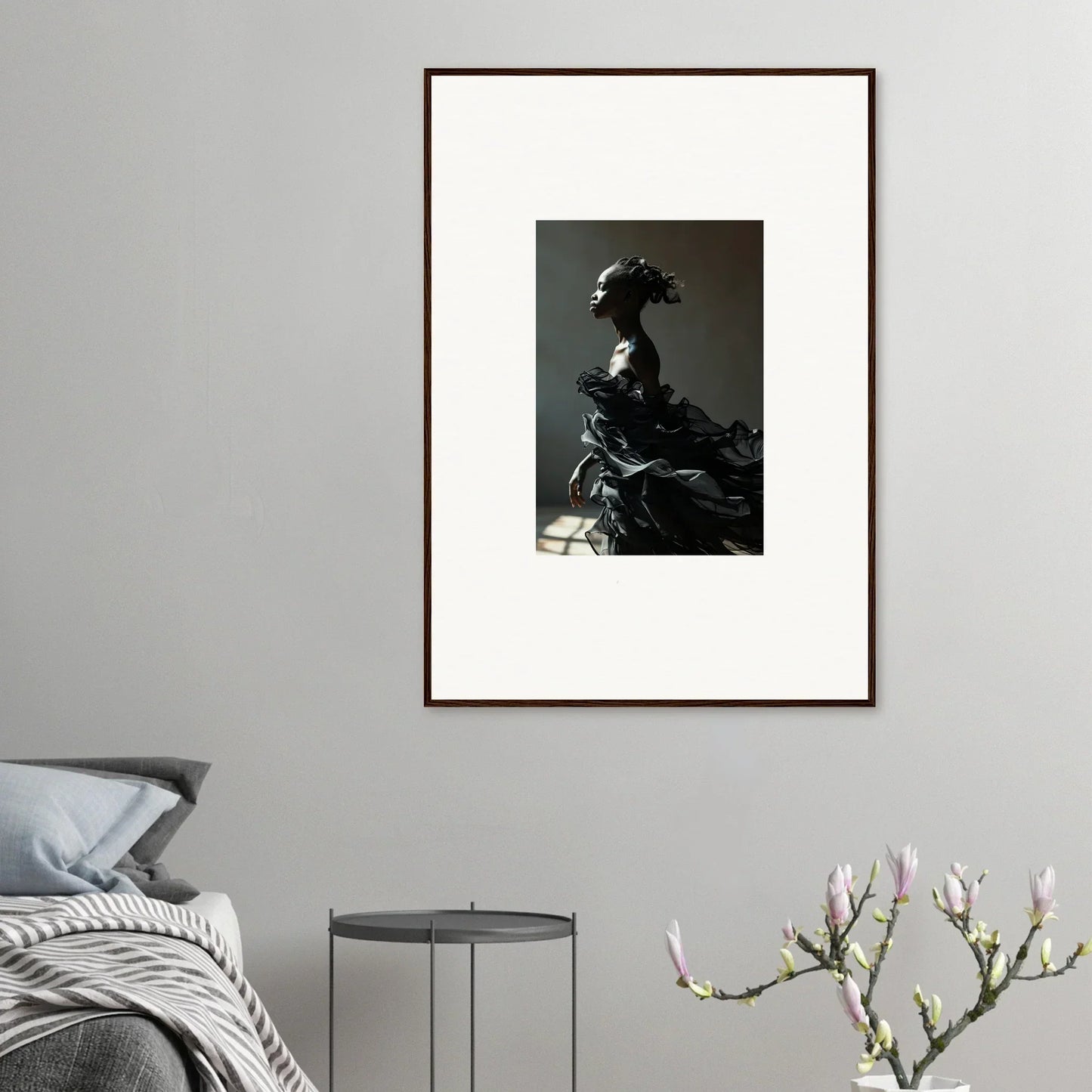 Framed black and white photograph of a figure in dramatic, sculptural attire.