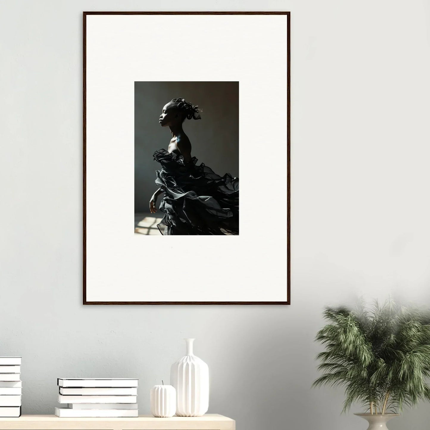 Framed black and white photograph of a figure in elaborate historical costume and headdress.