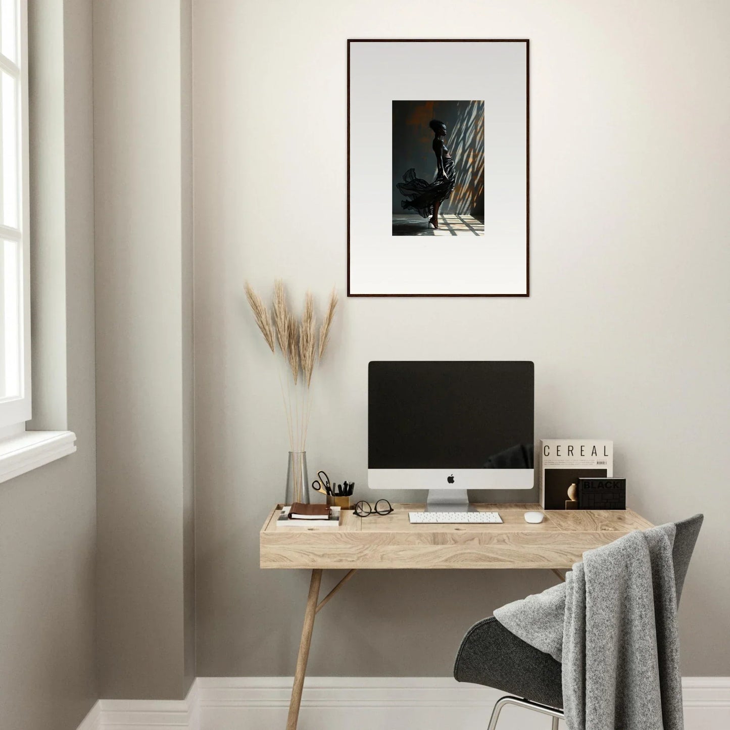 Minimalist wooden desk with a computer monitor and office accessories.