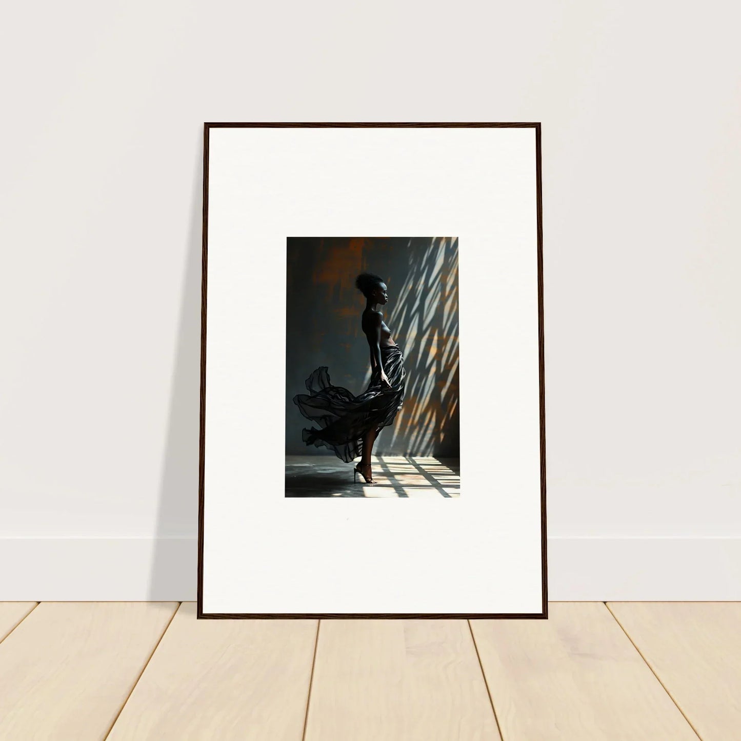 Framed photograph of a silhouetted figure standing in dramatic light and shadow.