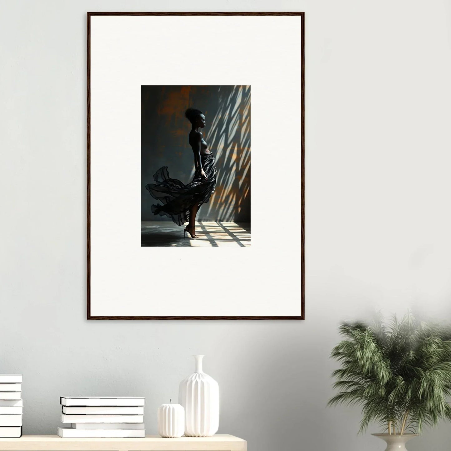 Framed photograph of a silhouetted figure standing in dramatic light and shadow.