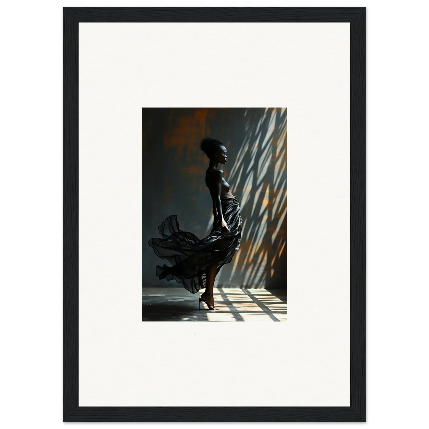 Silhouette of a person in a flowing dress standing dramatically in angled light.