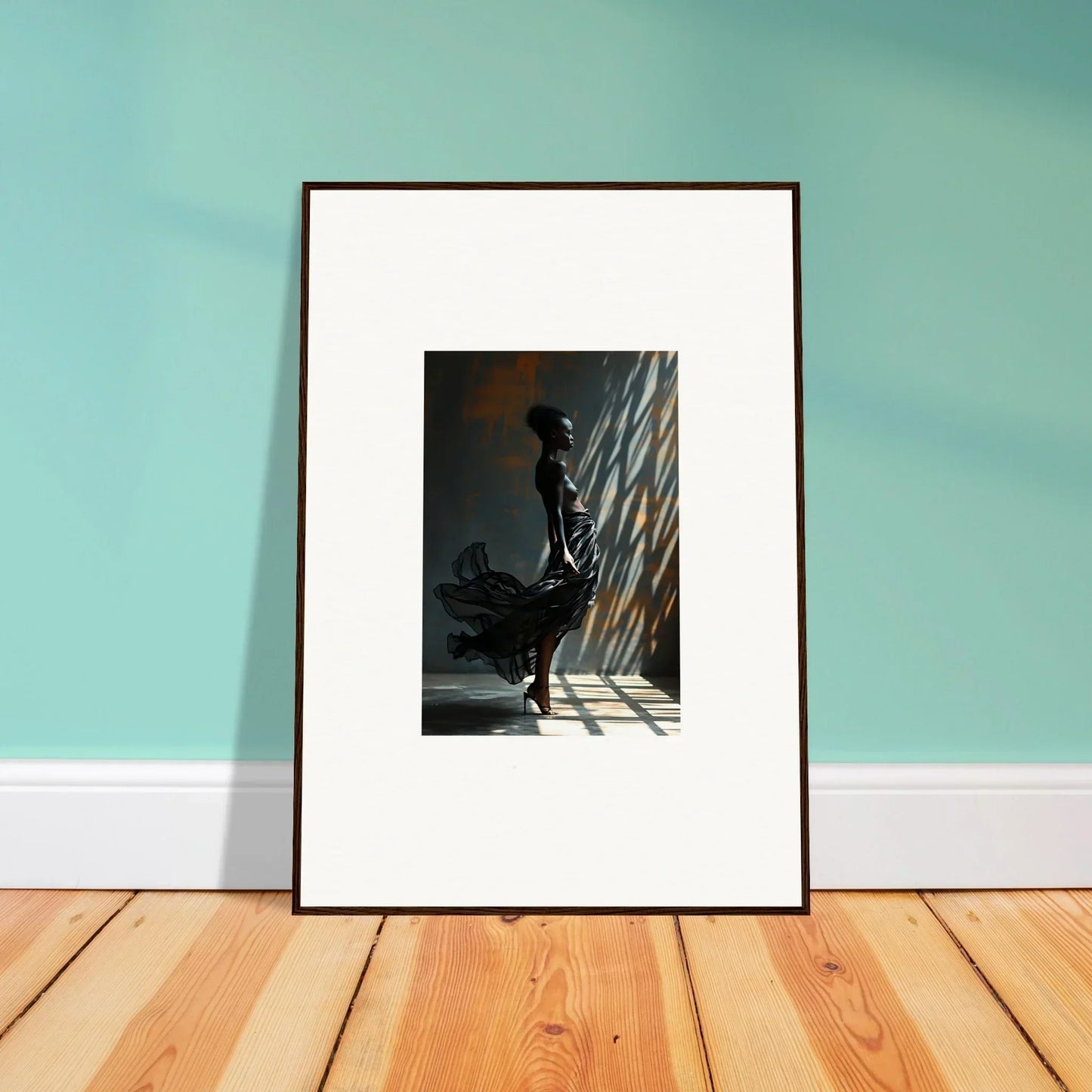 Framed black-and-white photograph of a silhouetted figure standing in dramatic light and shadow.