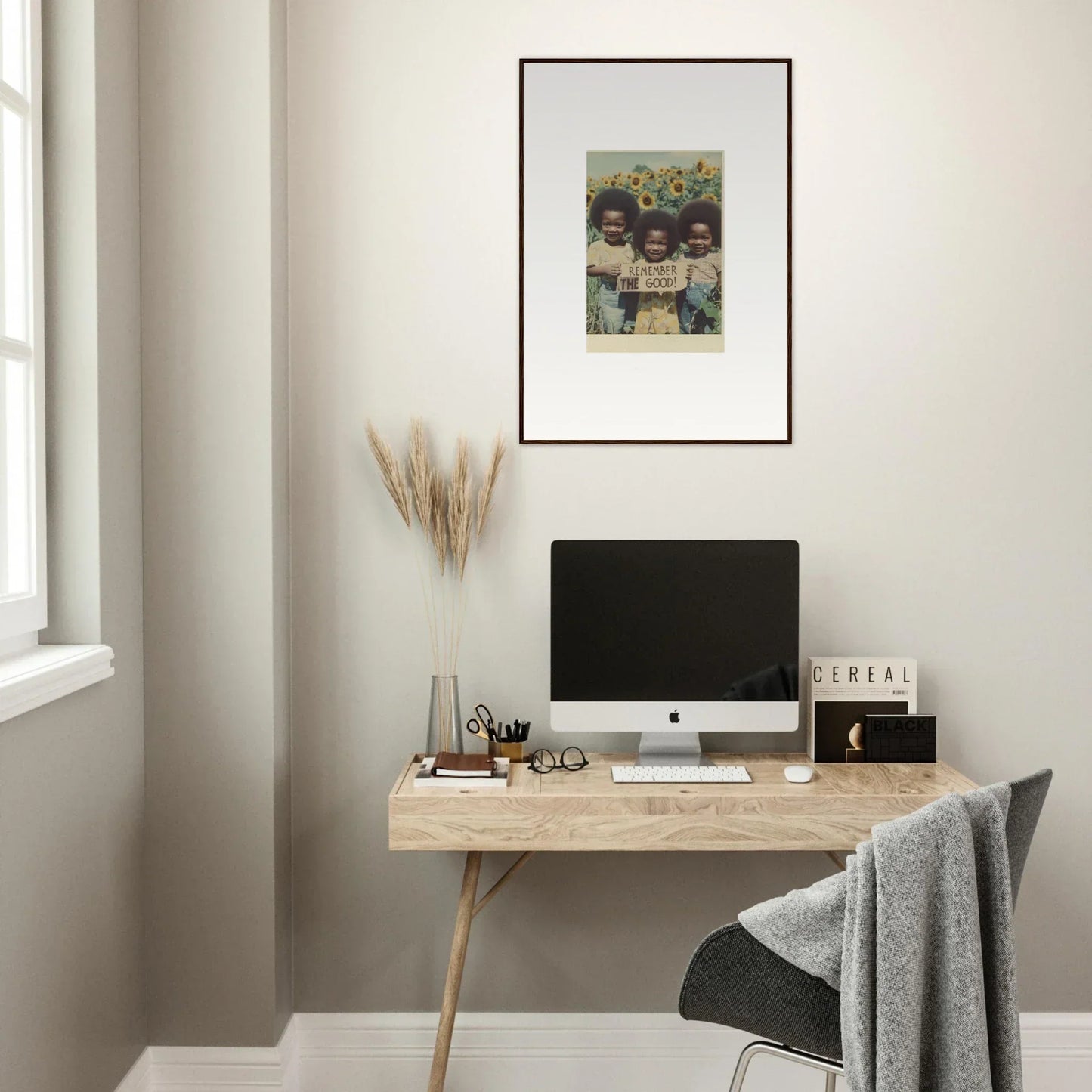 Minimalist wooden desk with a computer and canvas print for perfect bloom moments decor