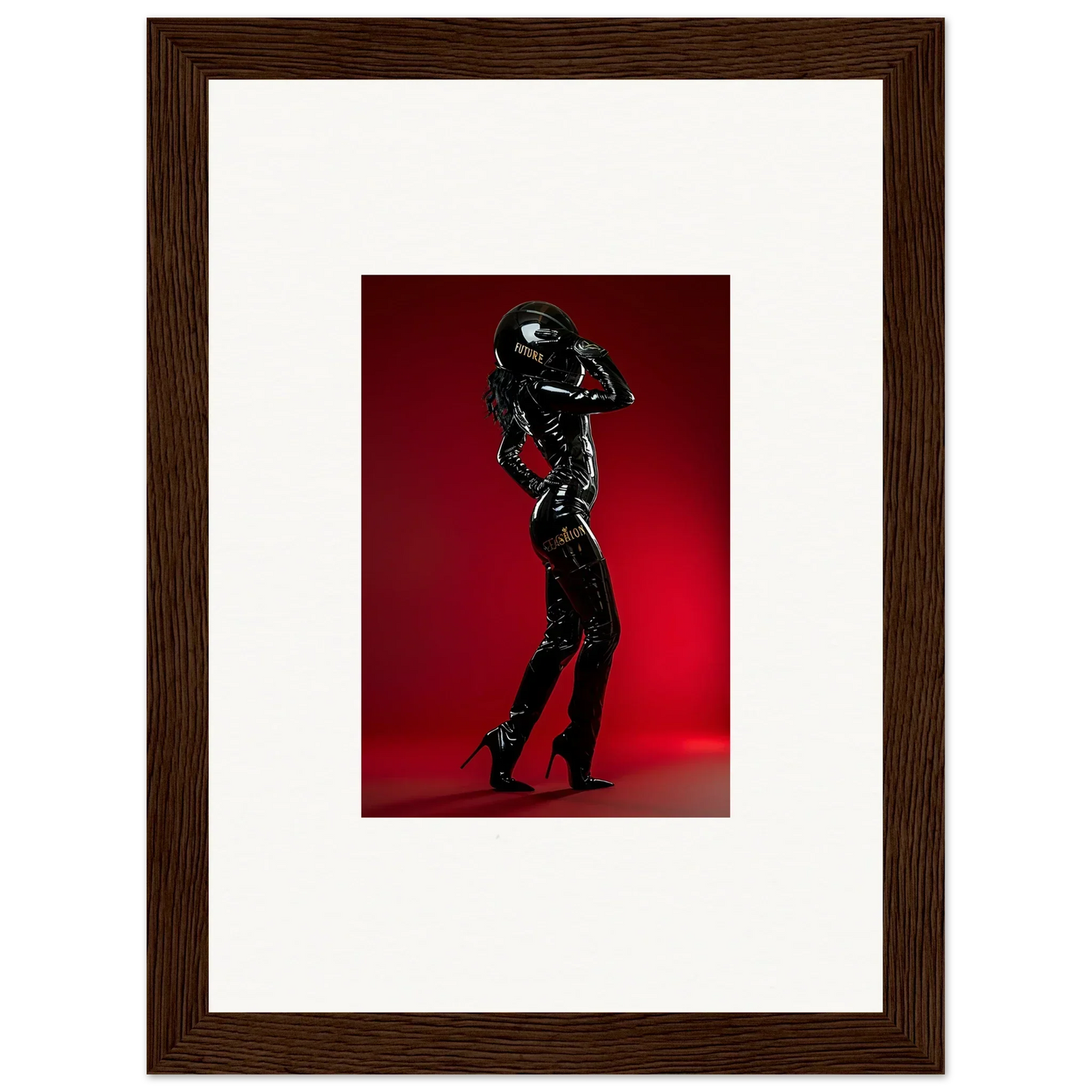 Framed photograph of a person posing in a shiny black outfit against a red backdrop.