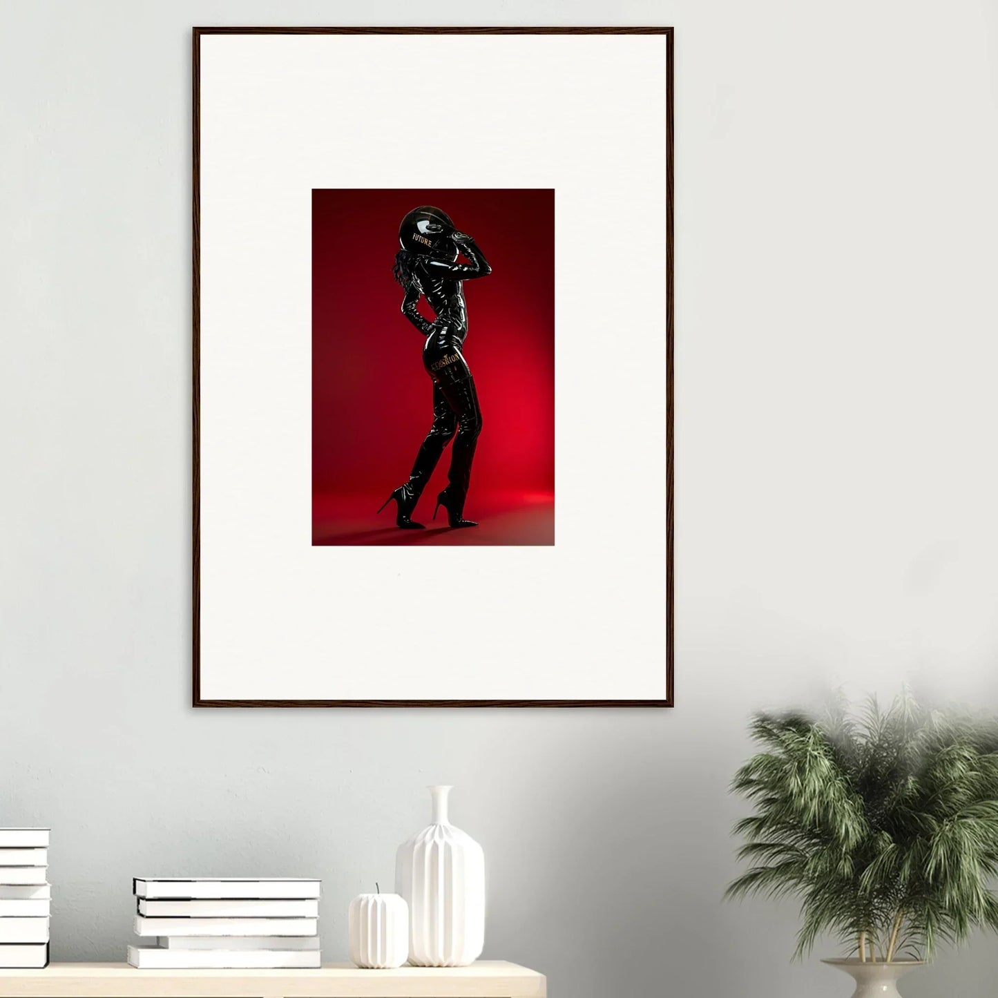 Framed photograph of a figure in black leather attire striking a dramatic pose against a red background.