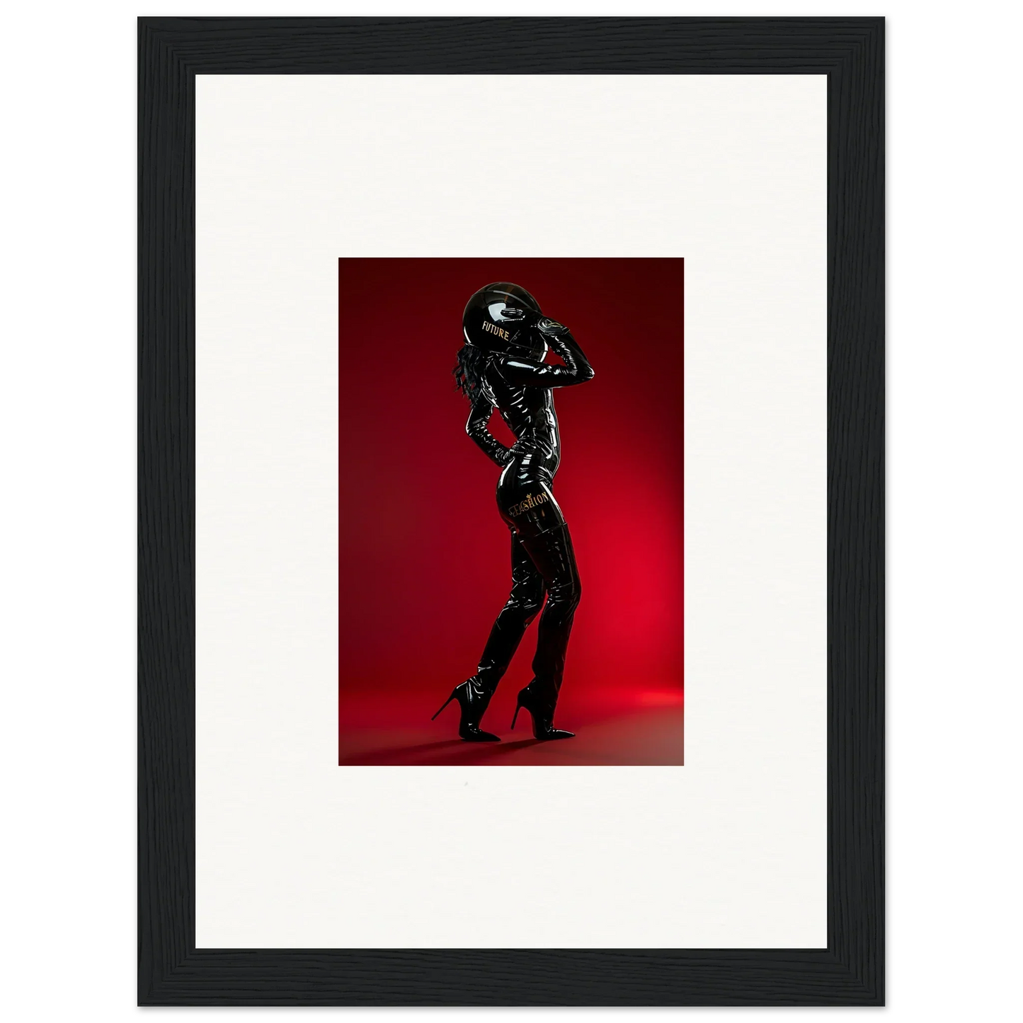 Framed photograph of a figure in a shiny black bodysuit striking a dramatic pose.