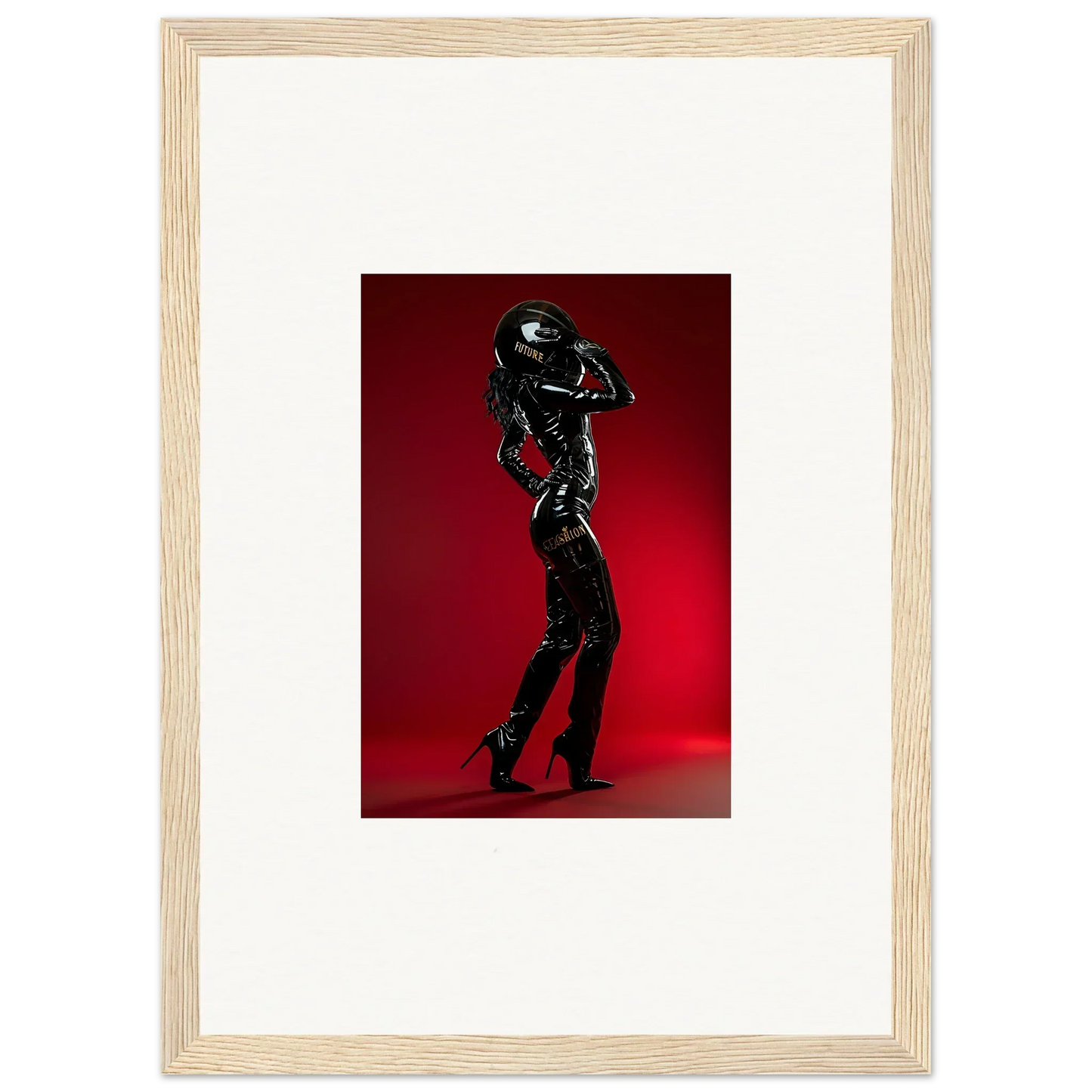 Framed photograph of a figure in a shiny black bodysuit striking a pose against a red backdrop.