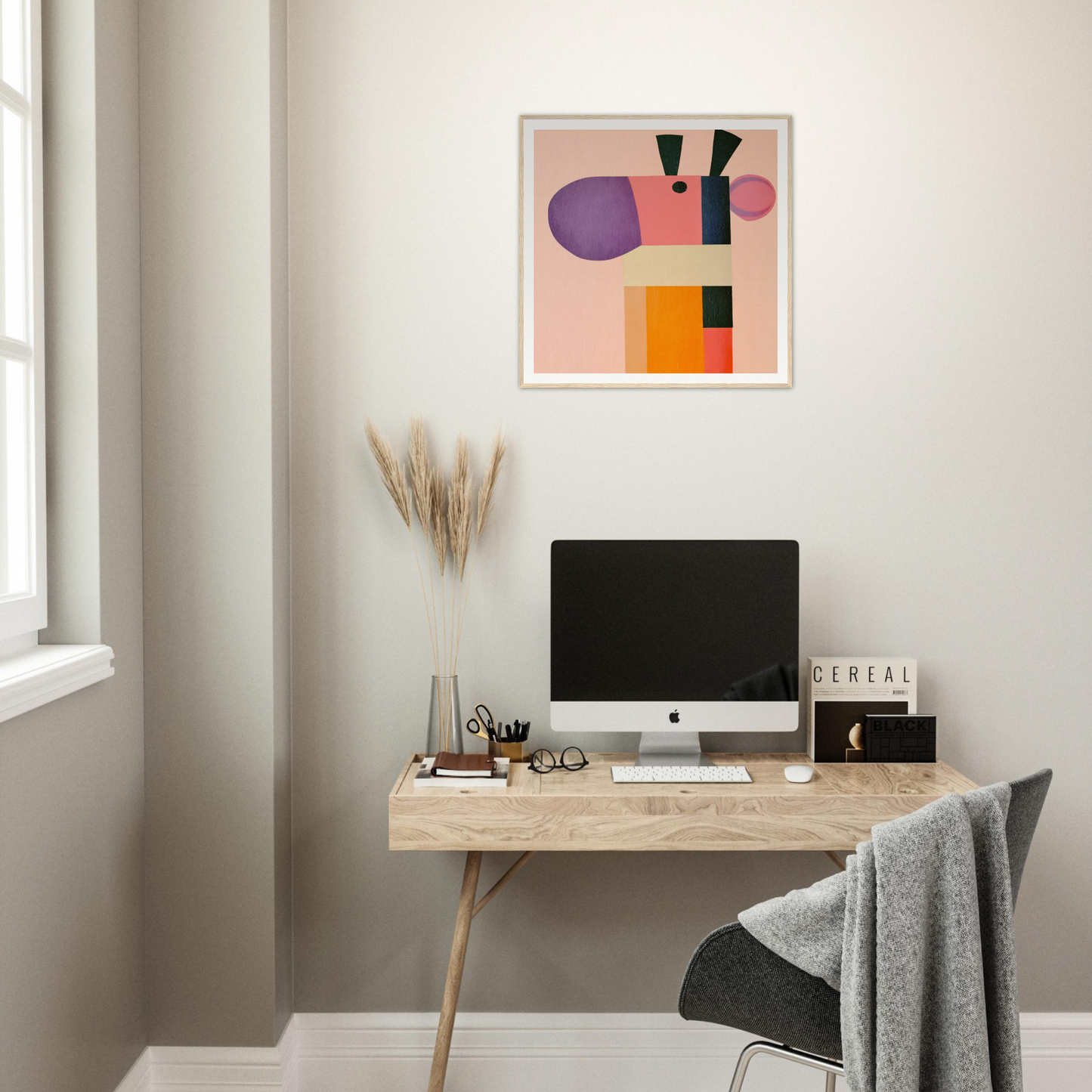 Minimalist wooden desk featuring iMac and abstract art from Giraffe’s Geometric Reverie