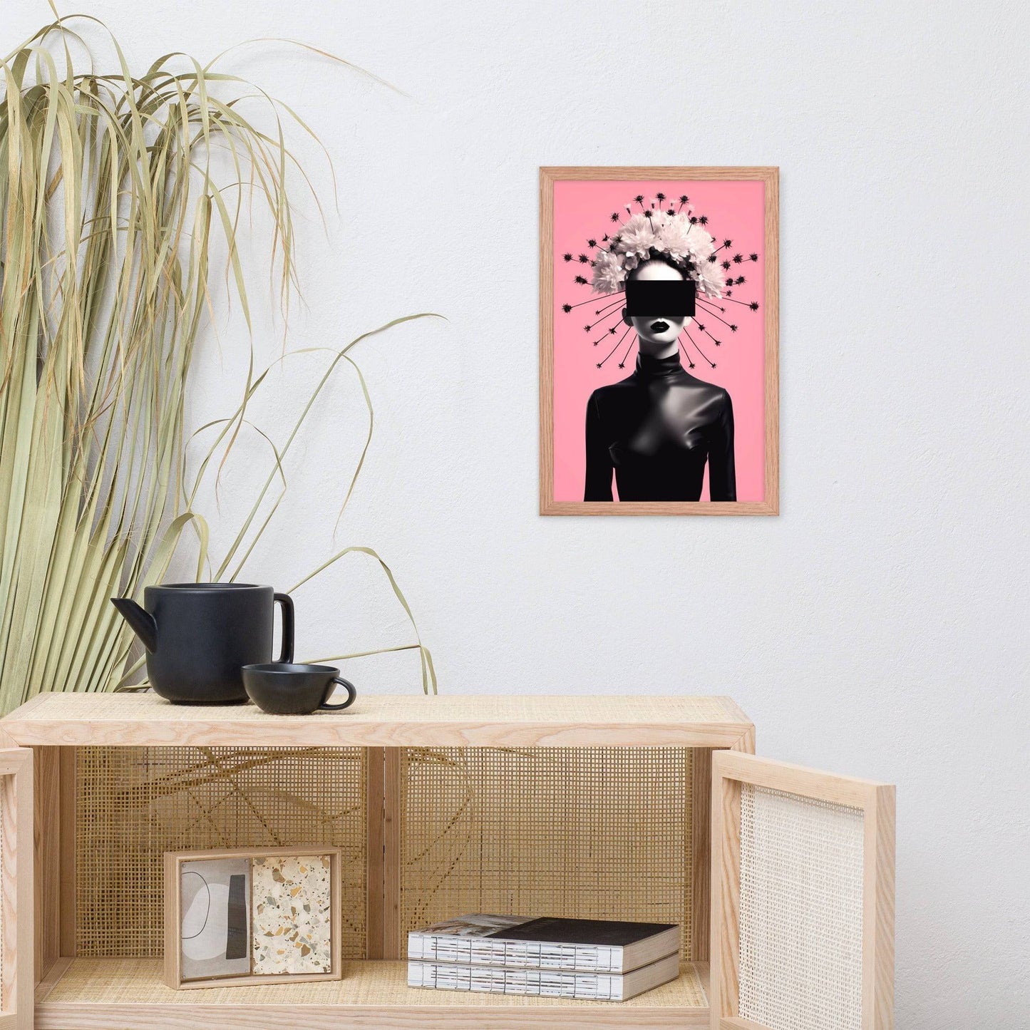 Framed artwork featuring a silhouetted figure with a crown-like burst of shapes on a pink background.