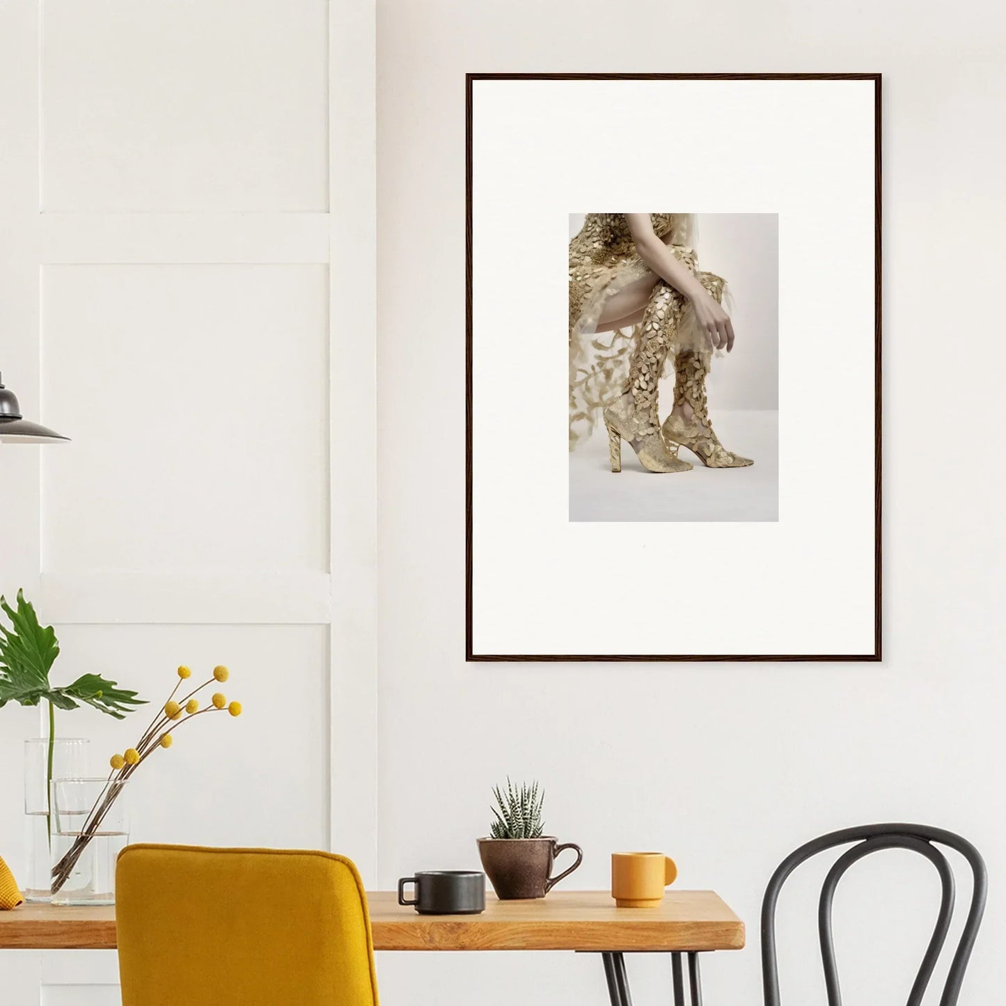 Framed artwork depicting a person’s lower body wearing gold sequined pants and high heels.