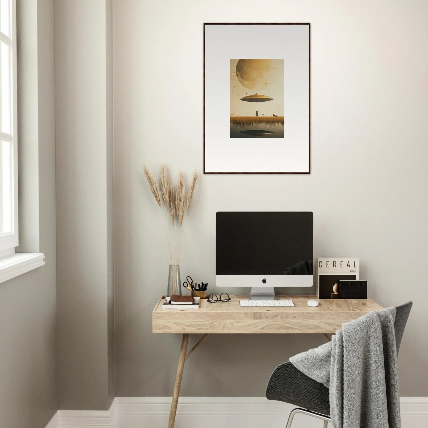 Minimalist home office with wooden desk, computer, and Moon Havinpierson framed wall art