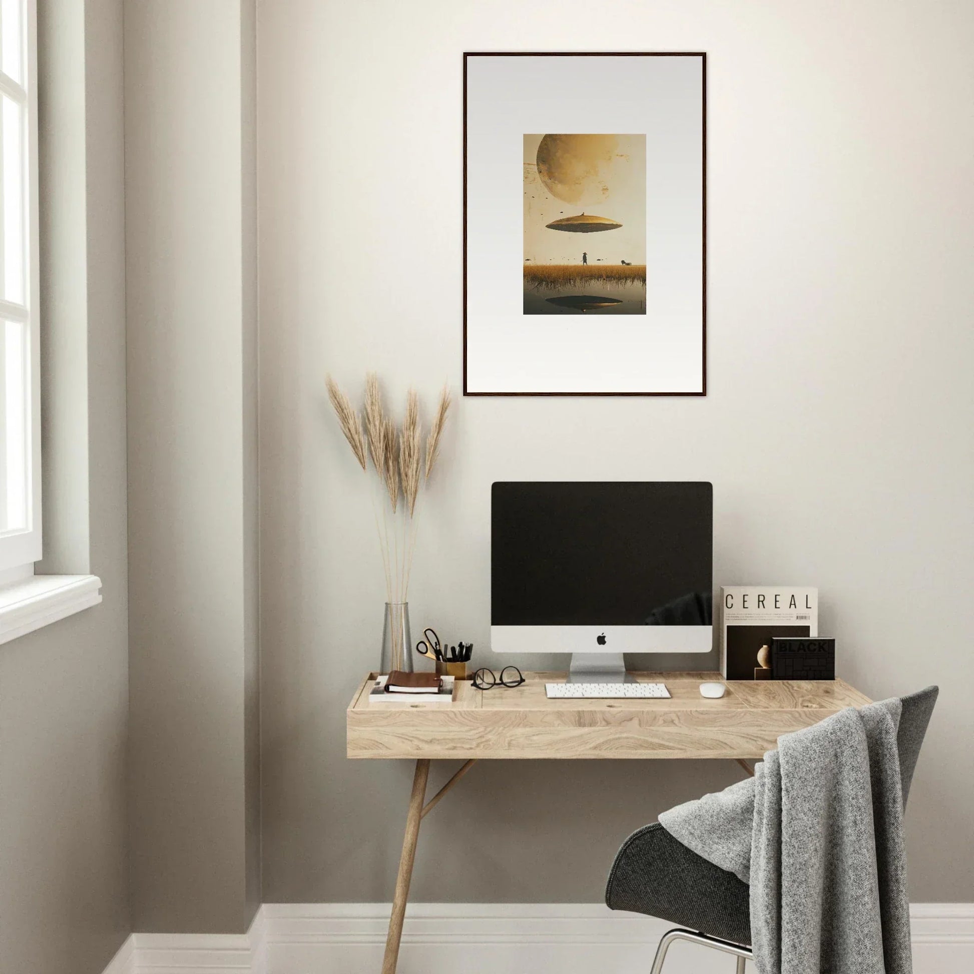 Minimalist home office with wooden desk, computer, and Moon Havinpierson framed wall art