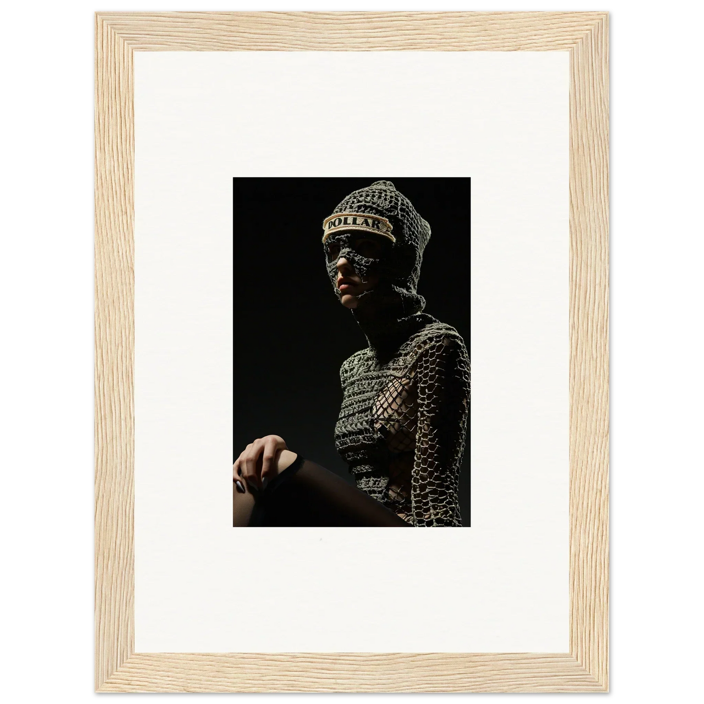 Framed photograph of a person wearing an ornate metallic headdress and armor-like garment against a dark background.