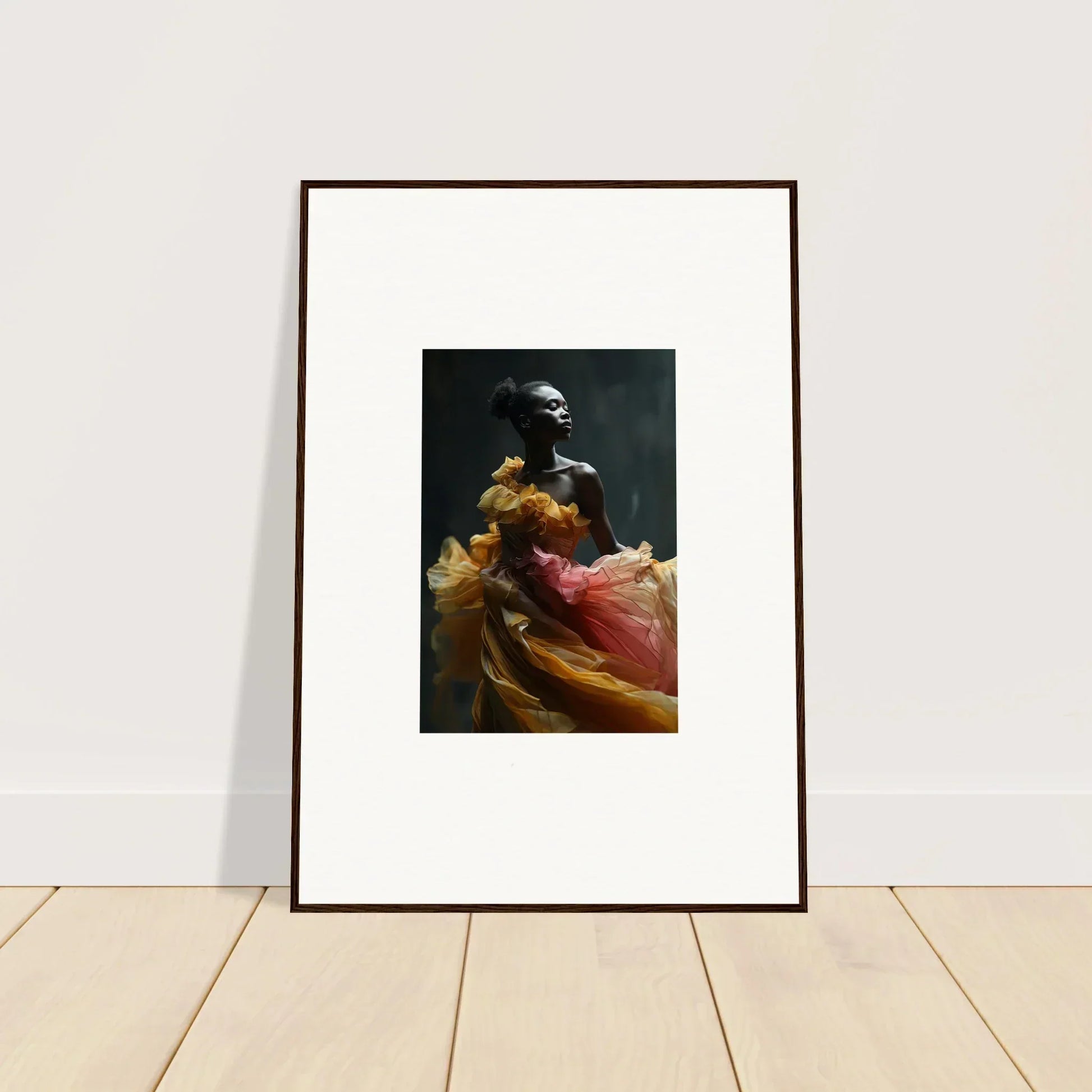 Framed photograph of a person wearing colorful flowing fabric against a dark background.