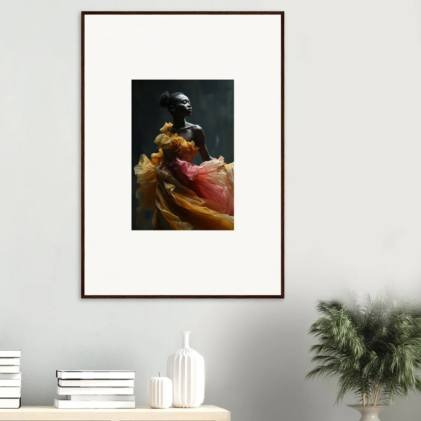 Framed artwork depicting a figure in flowing, colorful garments against a dark background.