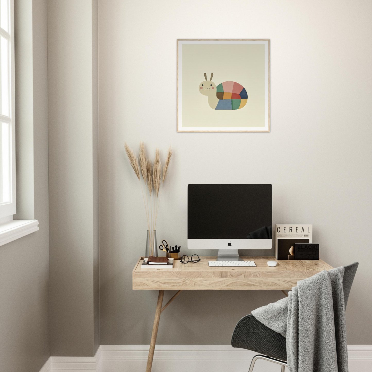 Minimalist wooden desk with iMac and colorful snail nursery wall art above it