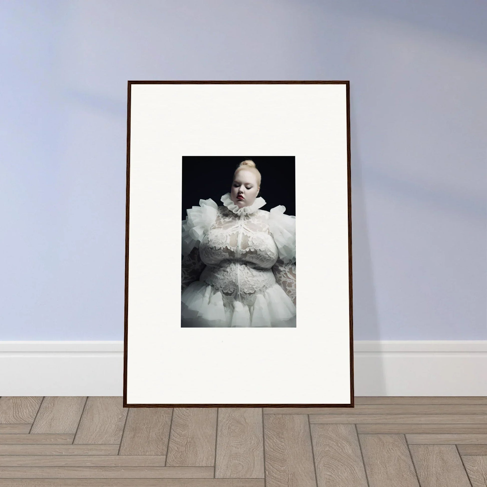 Framed black and white photograph of a baby wearing an elaborate white outfit.