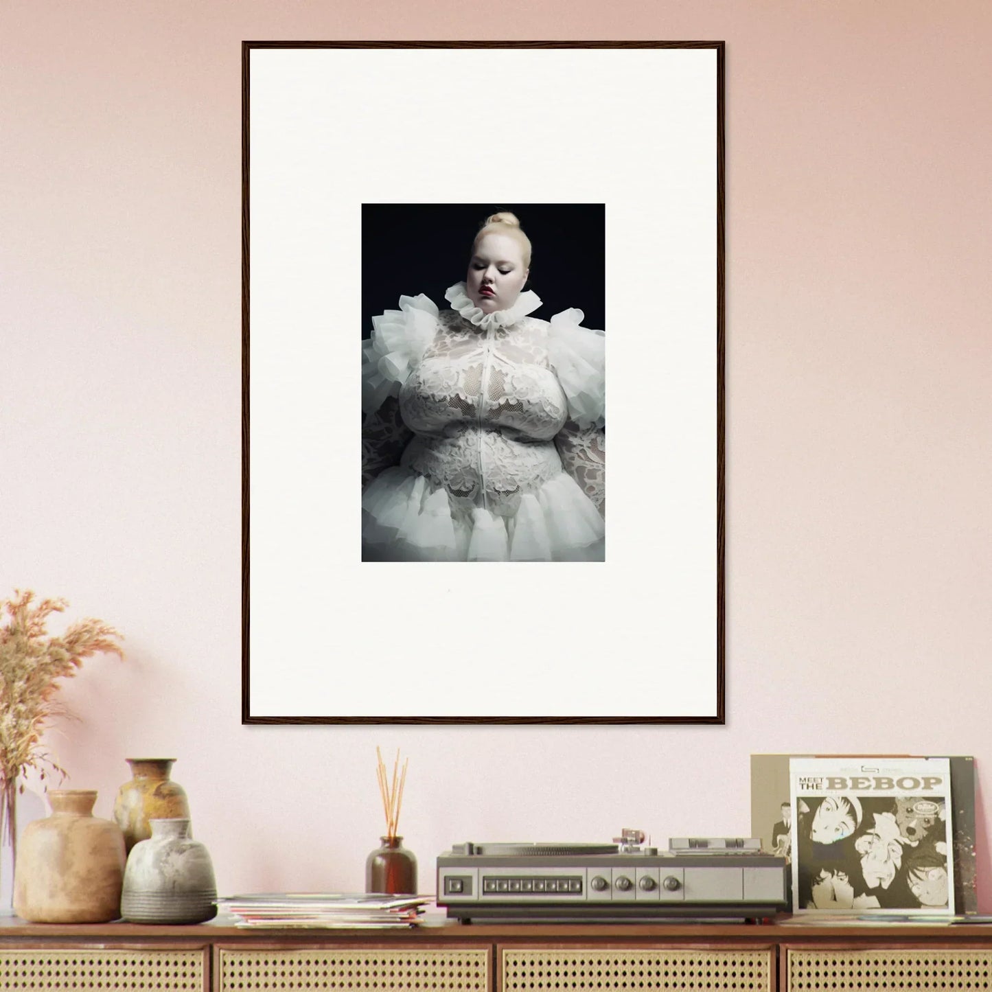 Framed black and white photograph of a baby in an ornate white outfit.