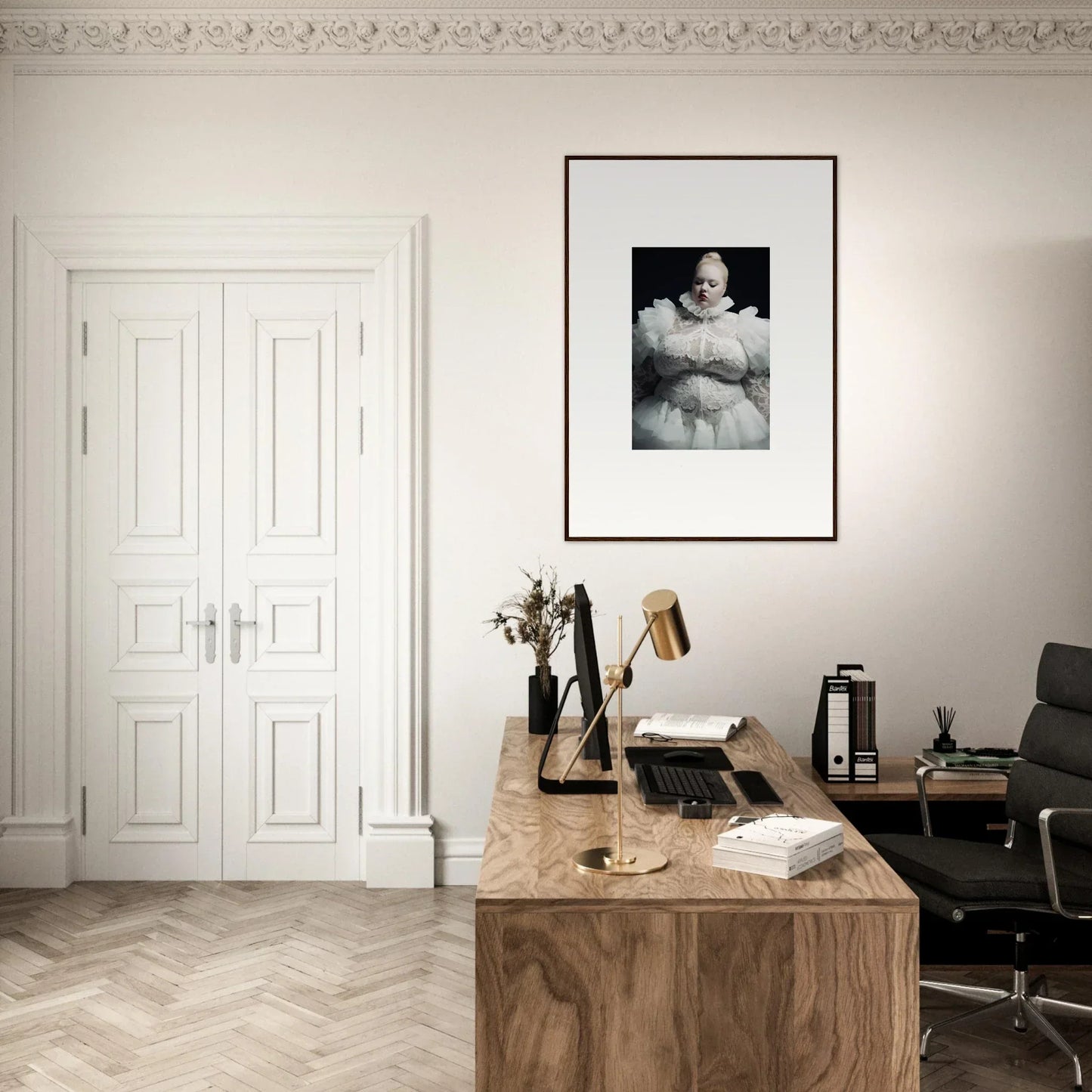 Home office workspace with a wooden desk, office chair, and framed artwork on the wall.